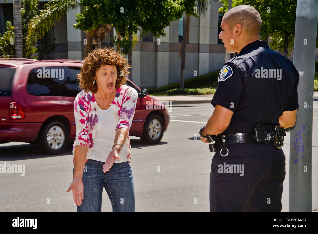 Une femme affirme avec un portrait policier après avoir été arrêté pour une infraction aux règlements de la circulation à Santa Ana, CA. Banque D'Images