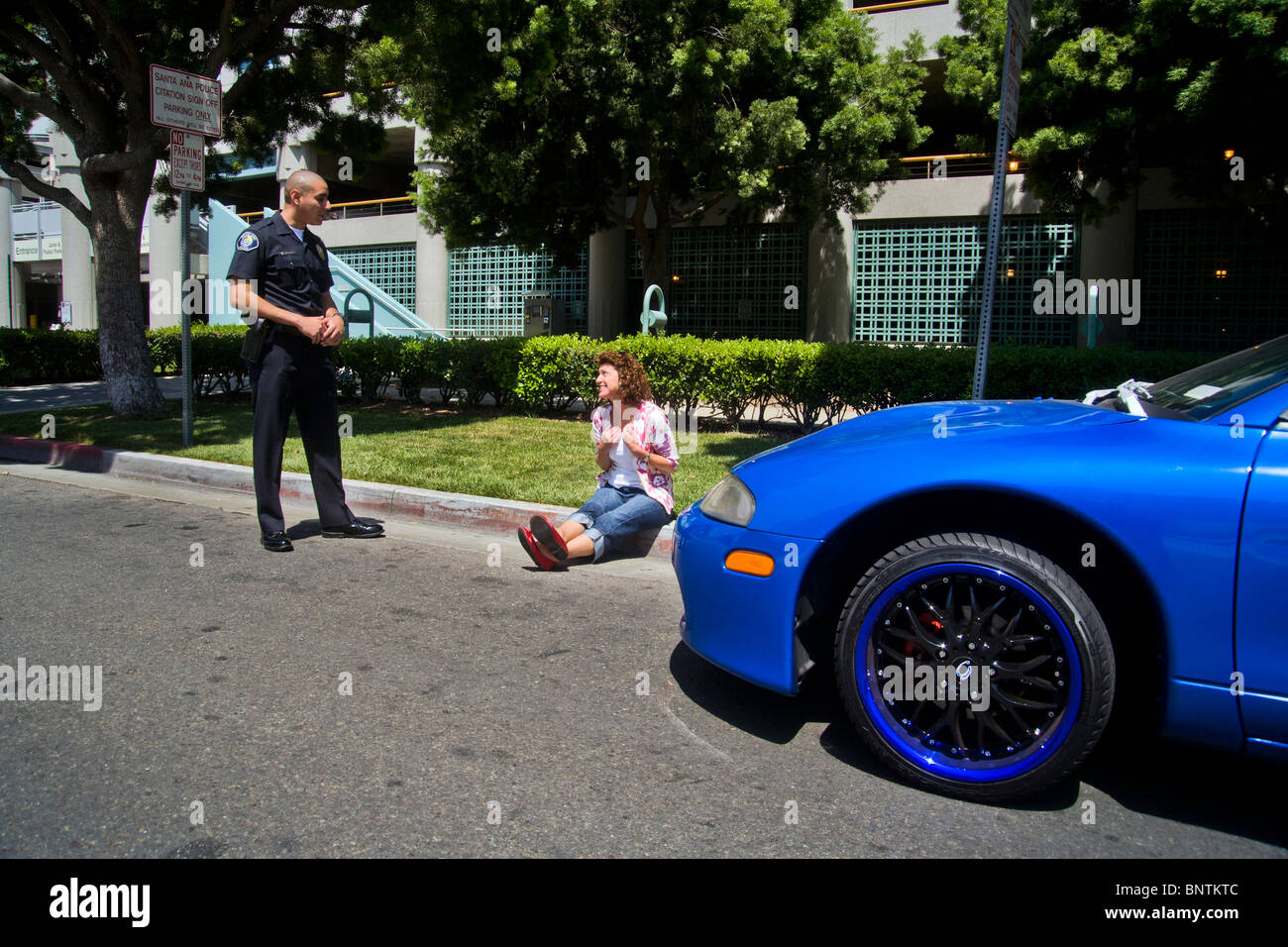 Une femme affirme avec un portrait policier après avoir été arrêté pour une infraction aux règlements de la circulation à Santa Ana, CA. Banque D'Images