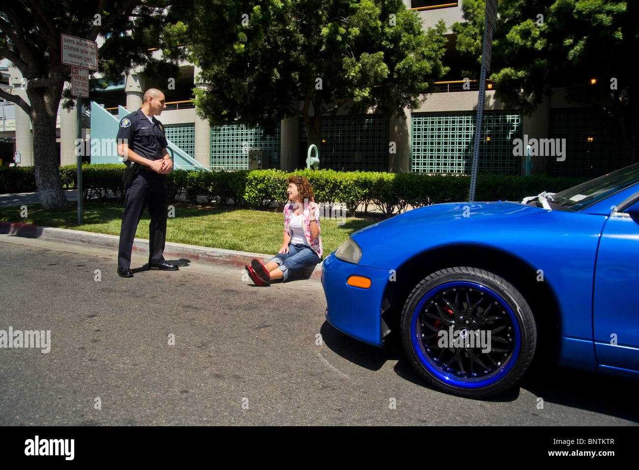 Une femme affirme avec un portrait policier après avoir été arrêté pour une infraction aux règlements de la circulation à Santa Ana, CA. Banque D'Images