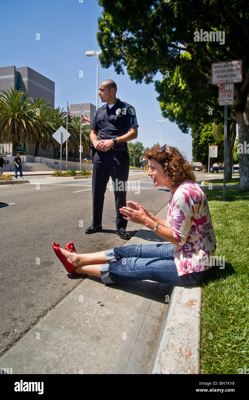 Une femme affirme avec un portrait policier après avoir été arrêté pour une infraction aux règlements de la circulation à Santa Ana, CA. Banque D'Images