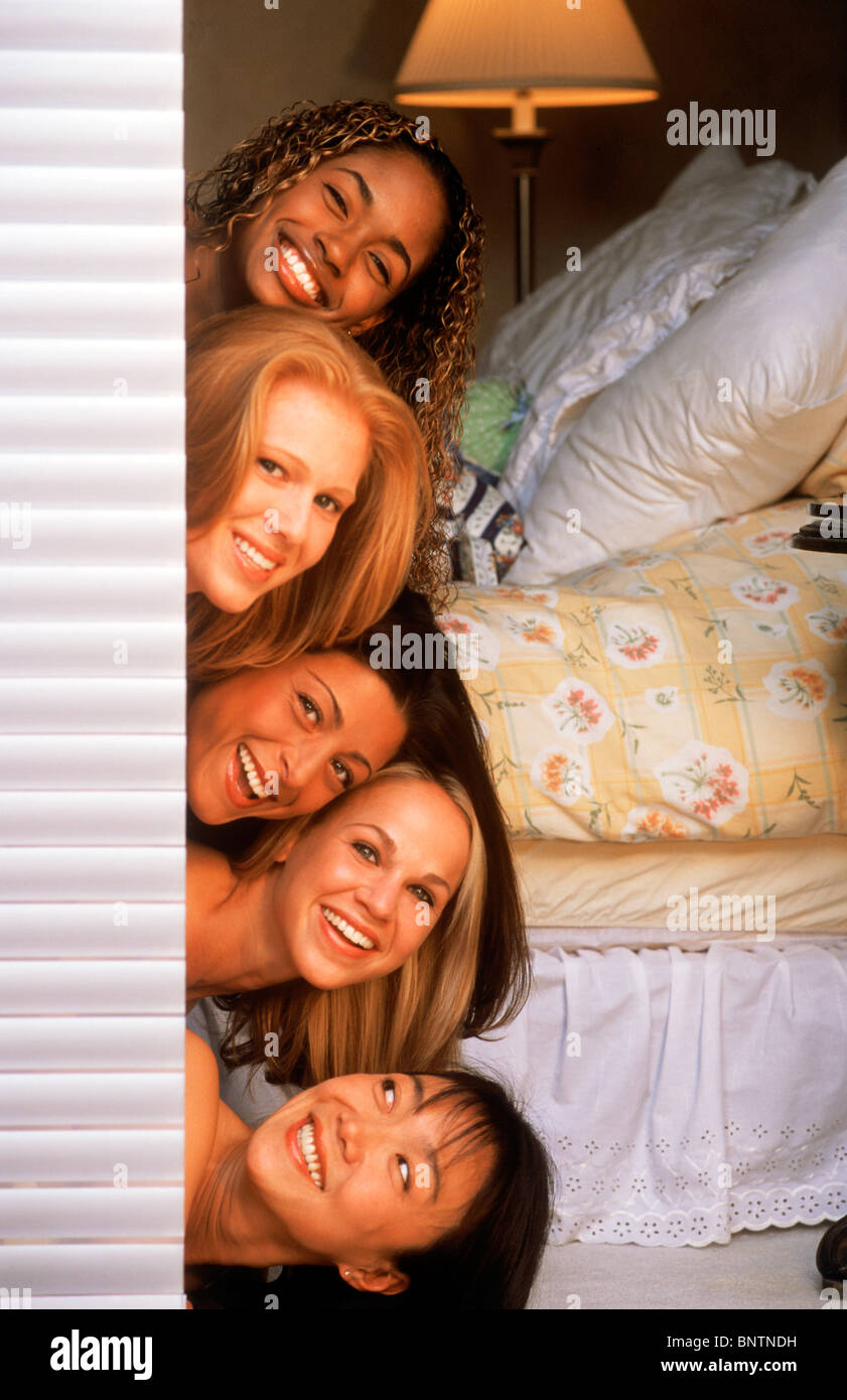Cinq femmes de composition ethnique empilées les unes sur les autres à la porte de chambre à coucher dehors Banque D'Images
