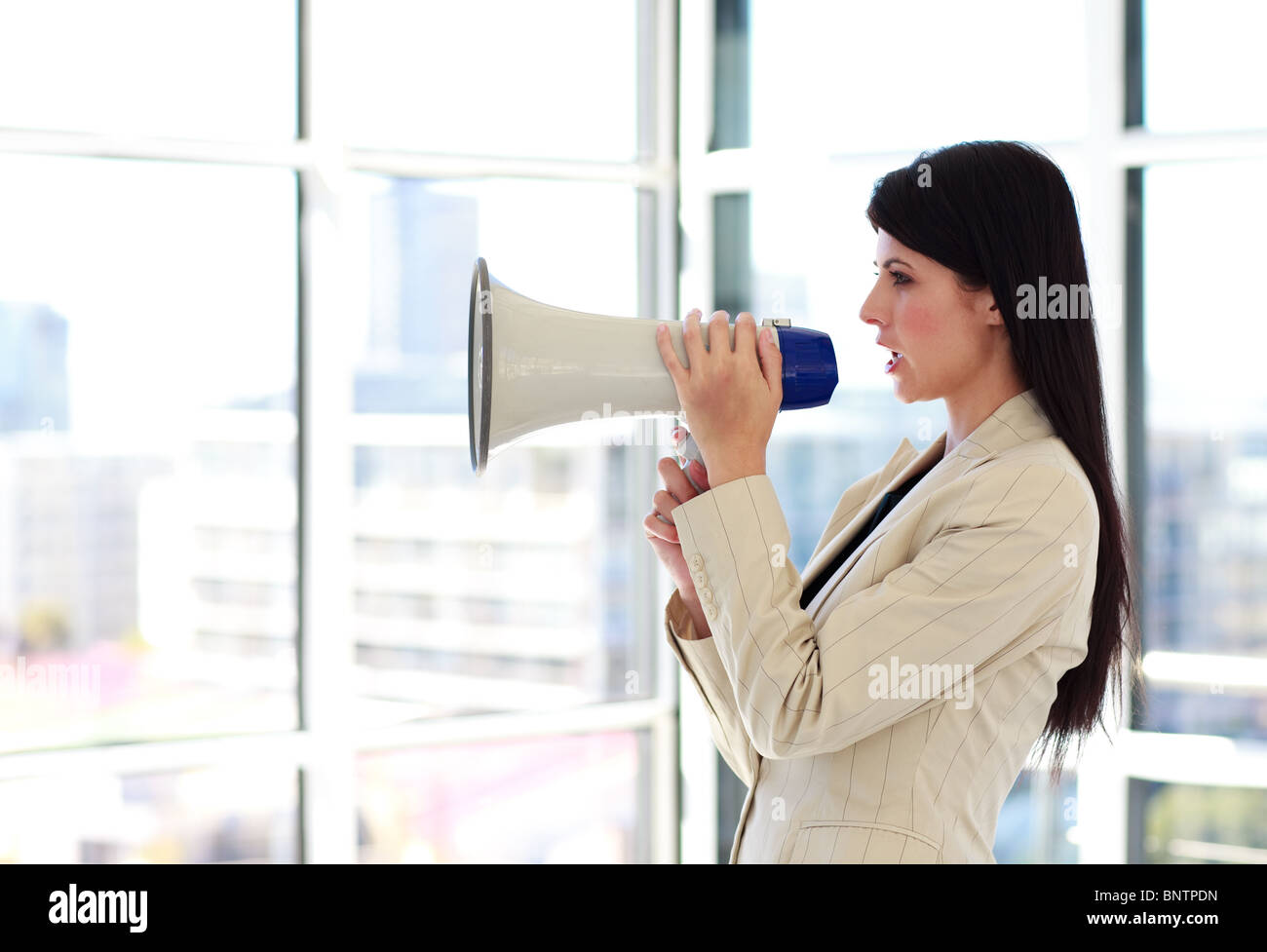 Young businesswoman crier par mégaphone Banque D'Images