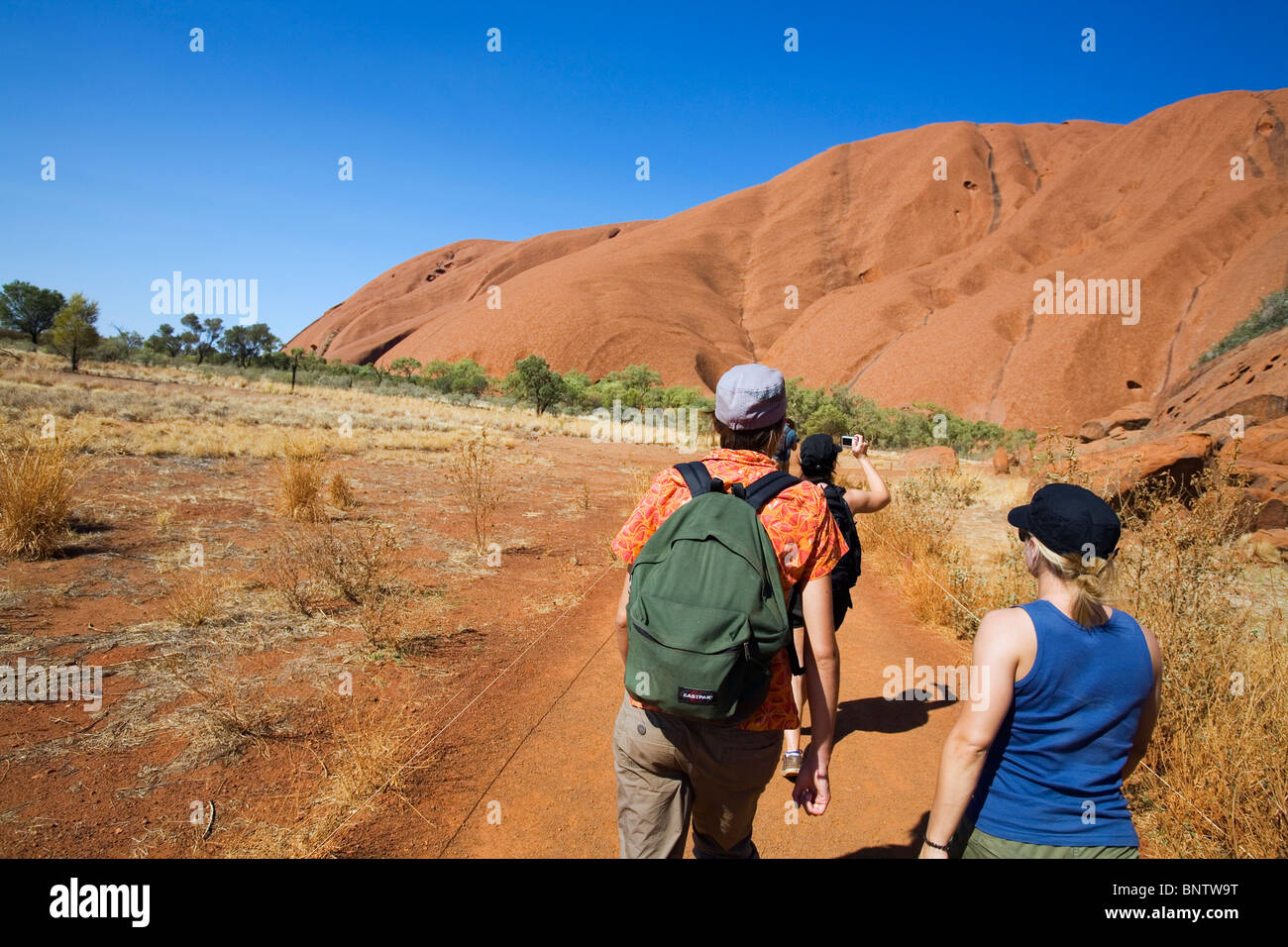 Les randonneurs sur l'Uluru (Ayers Rock) pied à pied. Le Parc National d'Uluru-Kata Tjuta, Territoire du Nord, Australie. Banque D'Images