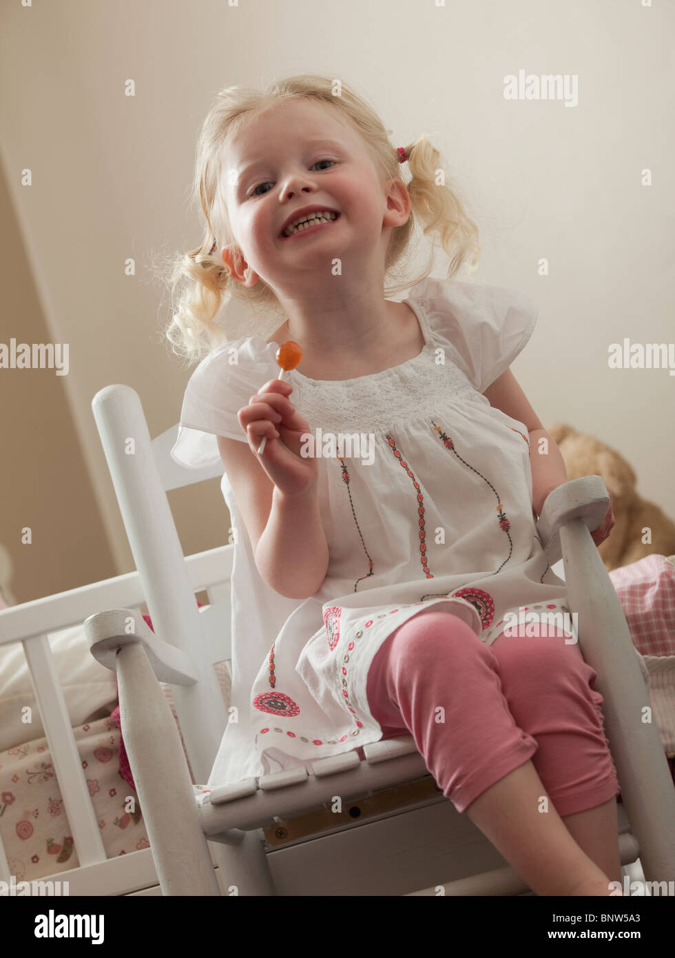 Jeune fille dans un fauteuil à bascule de manger une bonne poire Banque D'Images