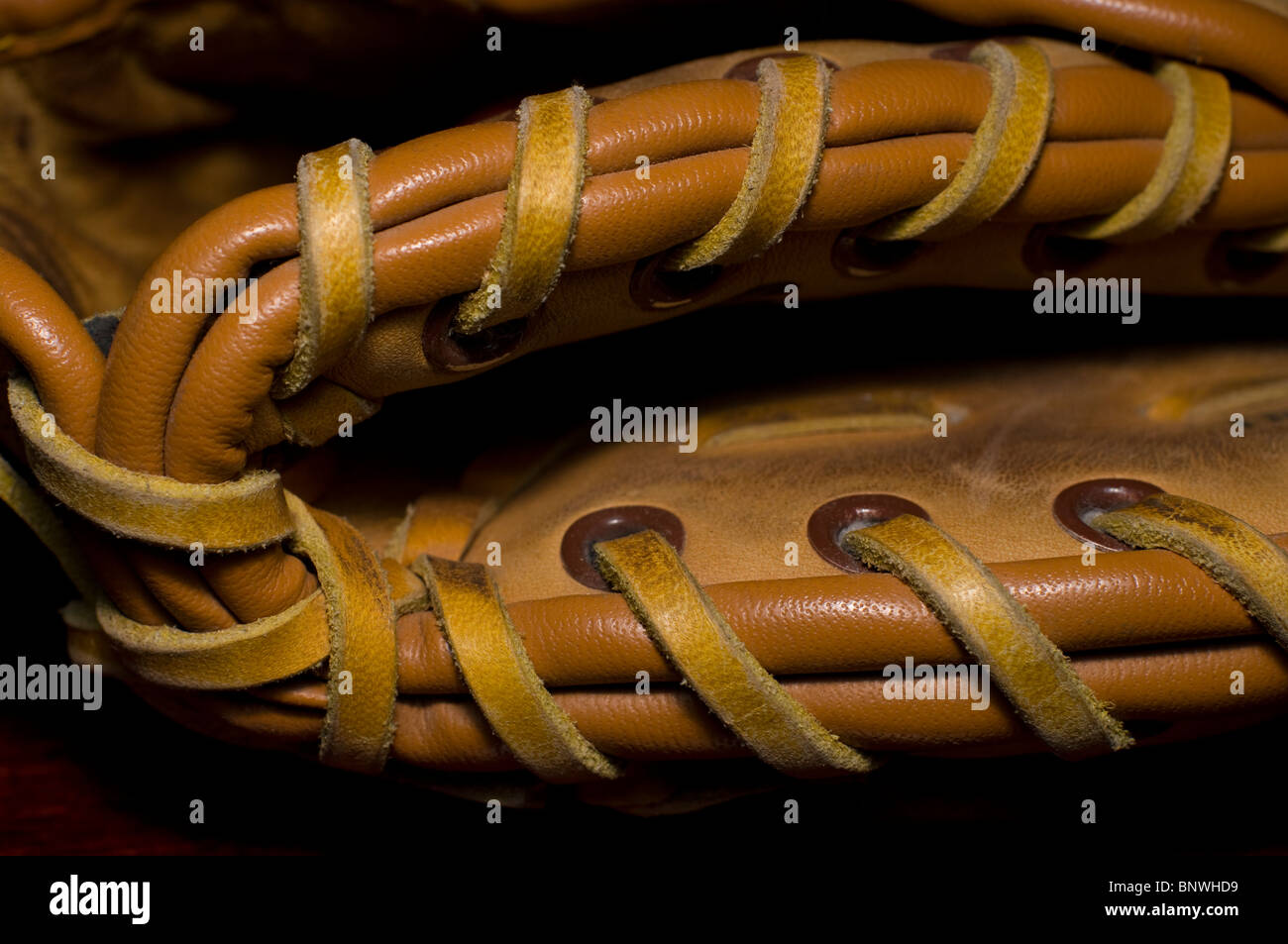 Close up artistique du talon d'une boule en cuir beige bien usé du gant couture. Le gant a clairement été bien utilisé. Banque D'Images