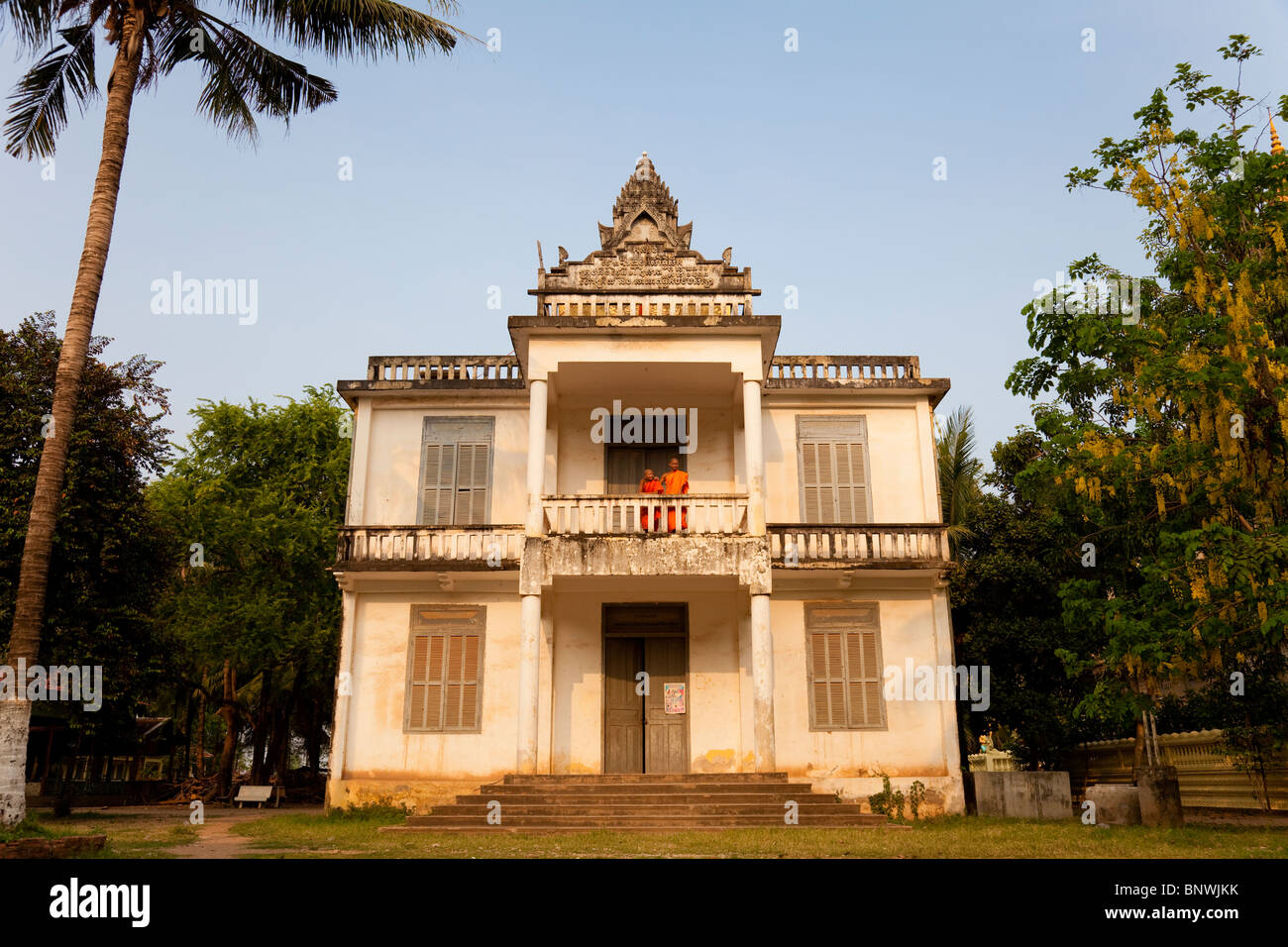 Deux moines debout sur le balcon d'une ancienne villa coloniale française - Province de Kandal, Cambodge Banque D'Images