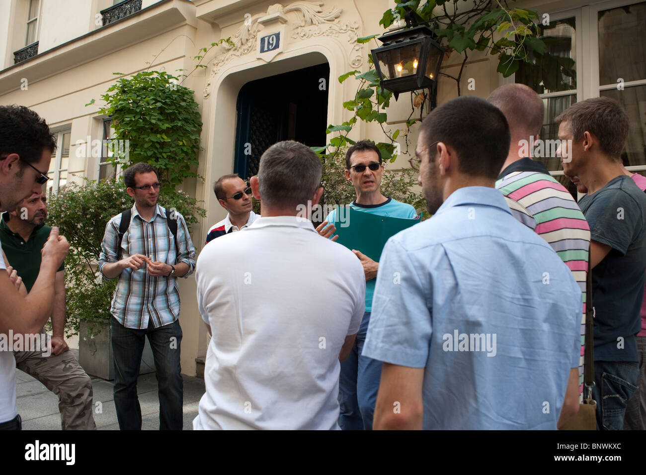 Groupe touristique adulte prenant la visite de l'histoire gay des années 80 de Paris par le guide de visite les groupes de direction, 'Hervé Taulière'. (Herve la Tapie) Banque D'Images