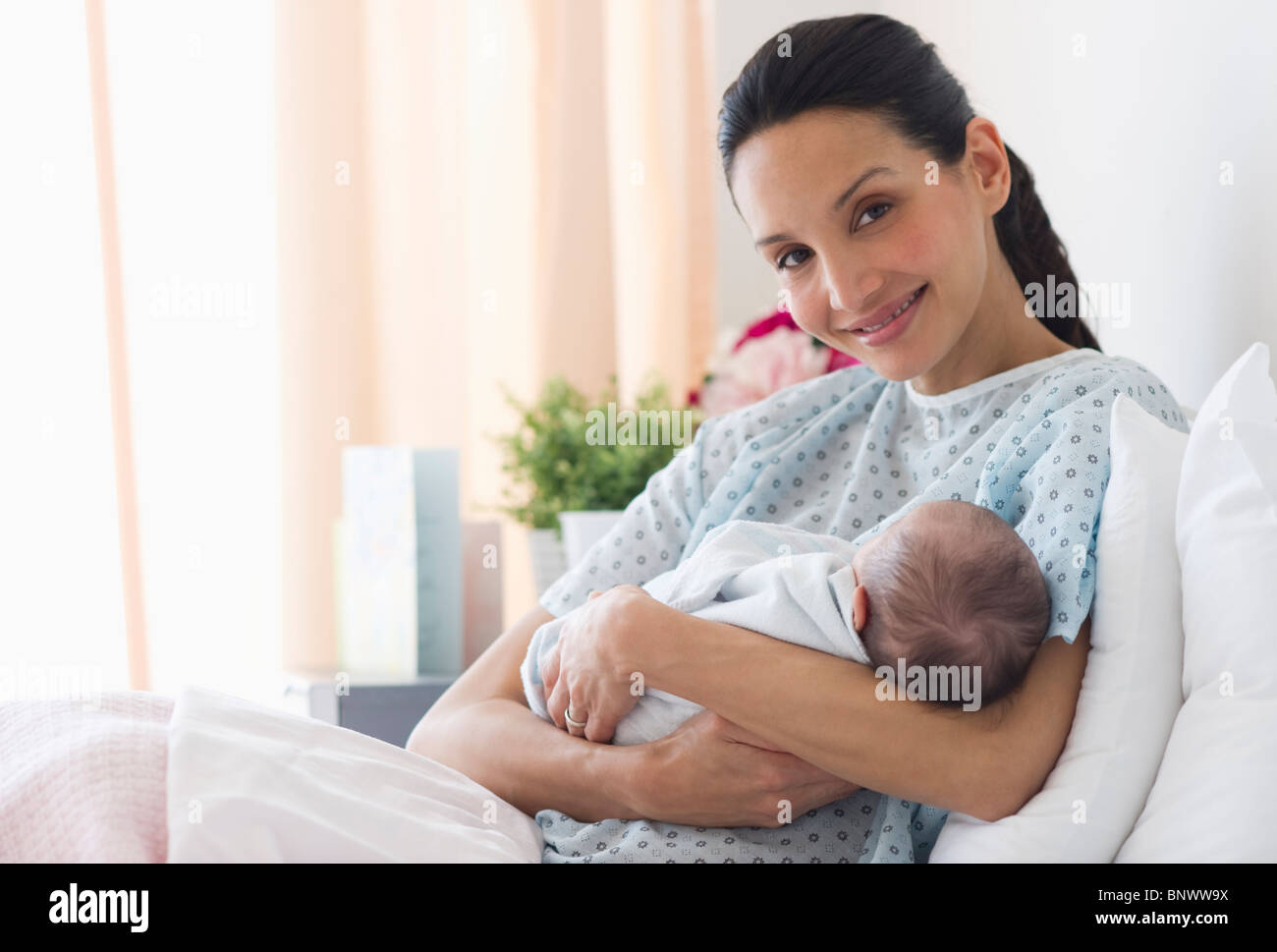 Mother holding newborn baby in hospital bed Banque D'Images