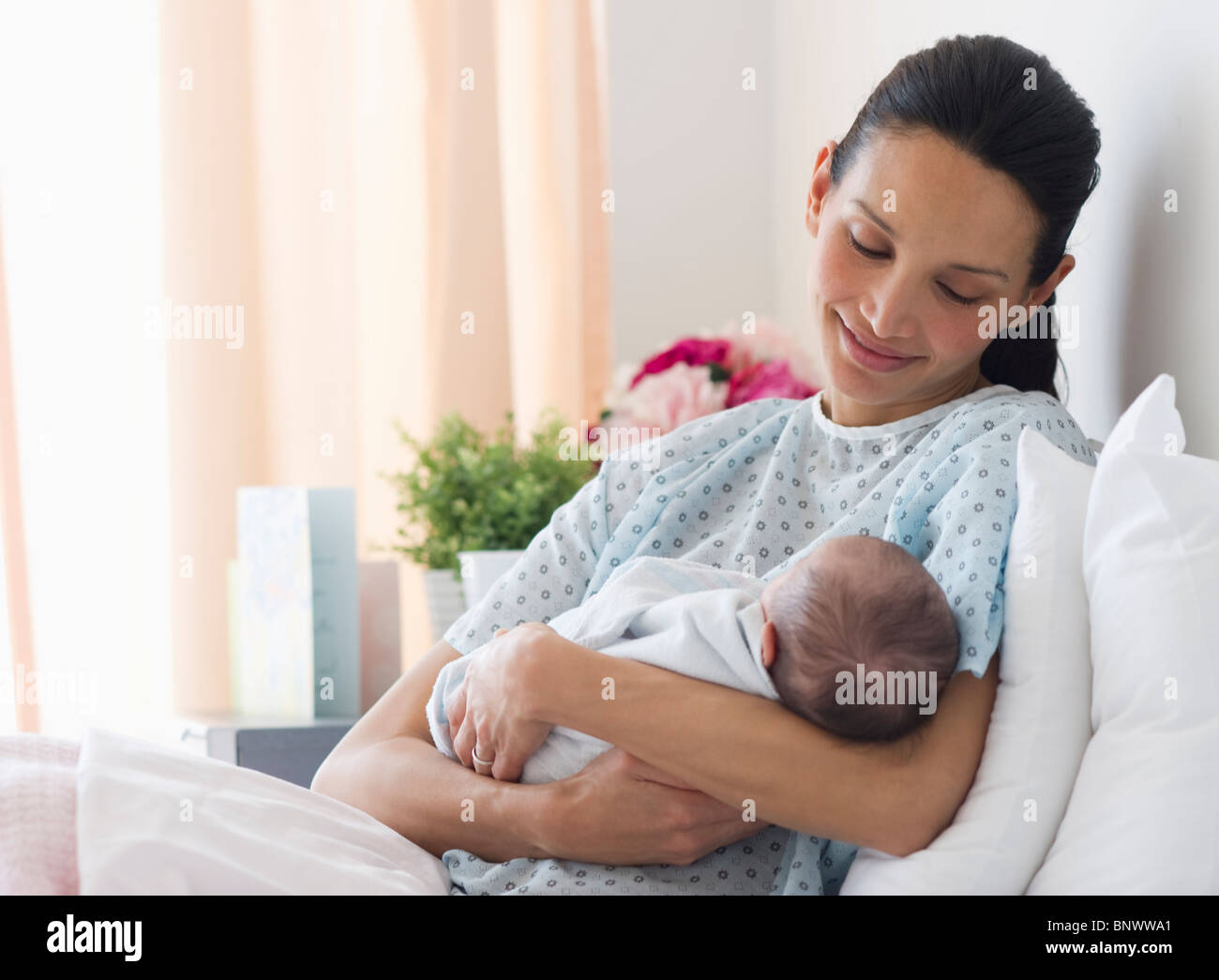 Mother holding newborn baby in hospital bed Banque D'Images