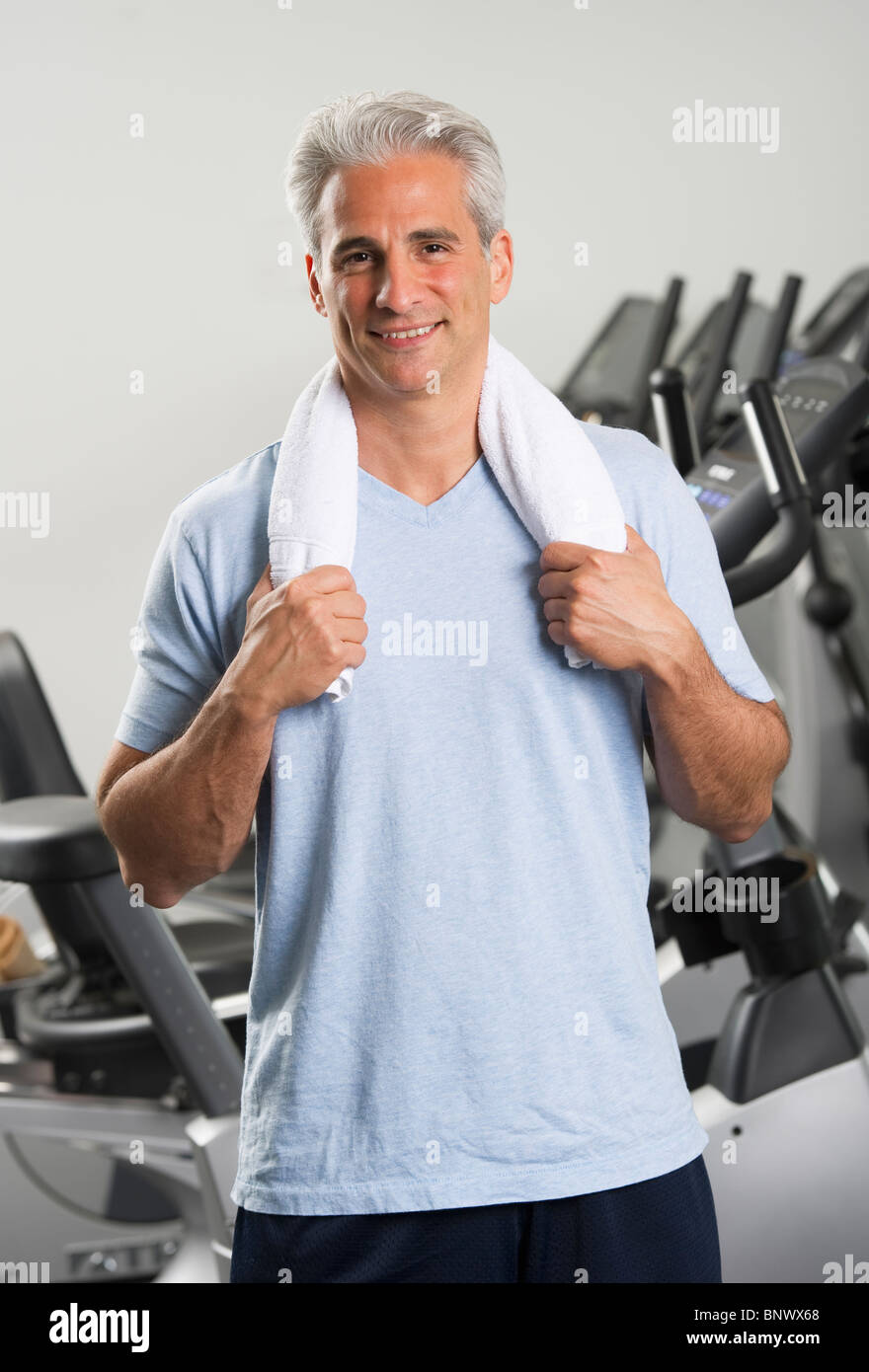 L'homme dans la salle de sport comité permanent avec une serviette autour du cou Banque D'Images