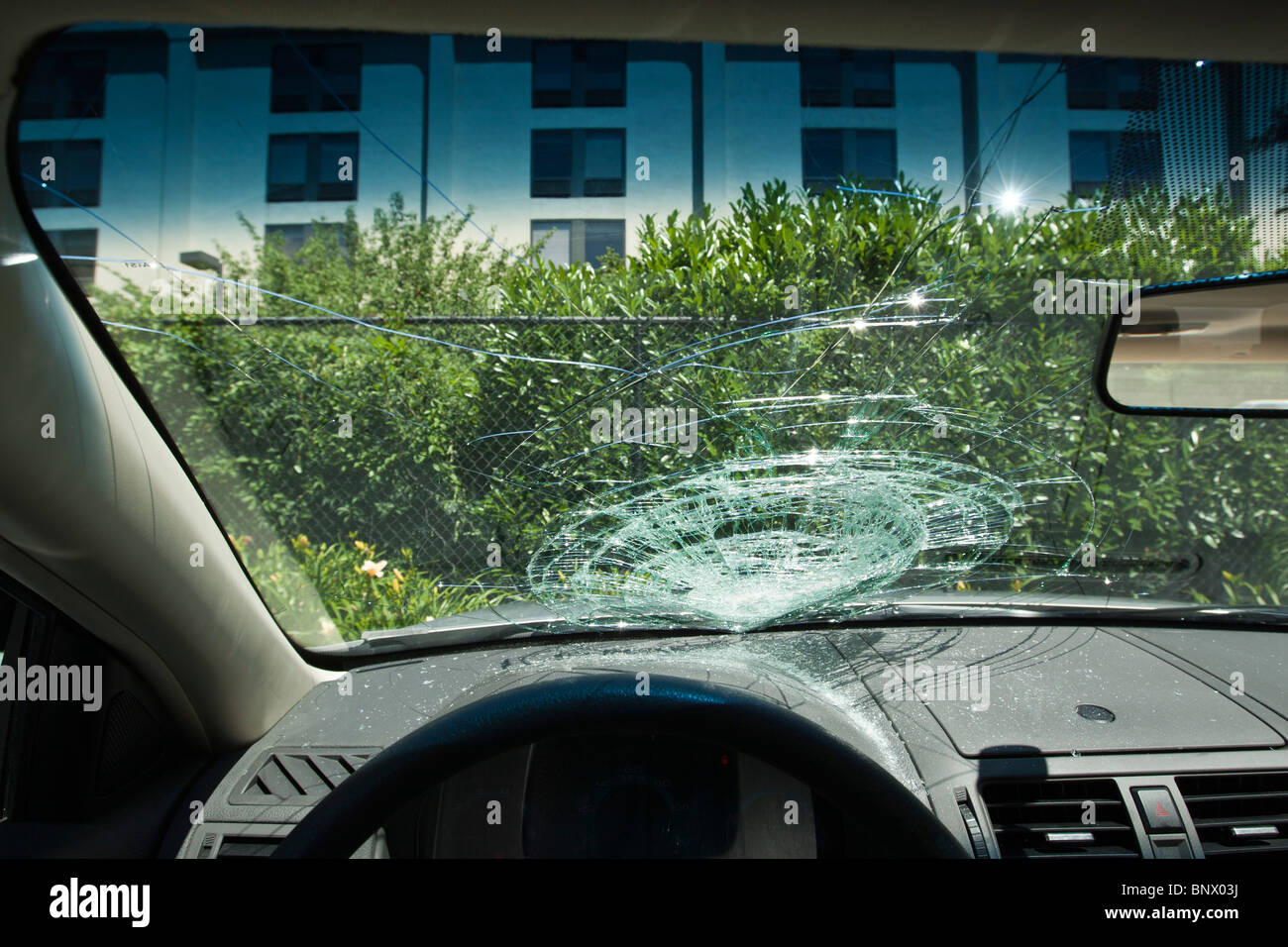 Avant pare-brise fracassé d'une voiture en stationnement Banque D'Images