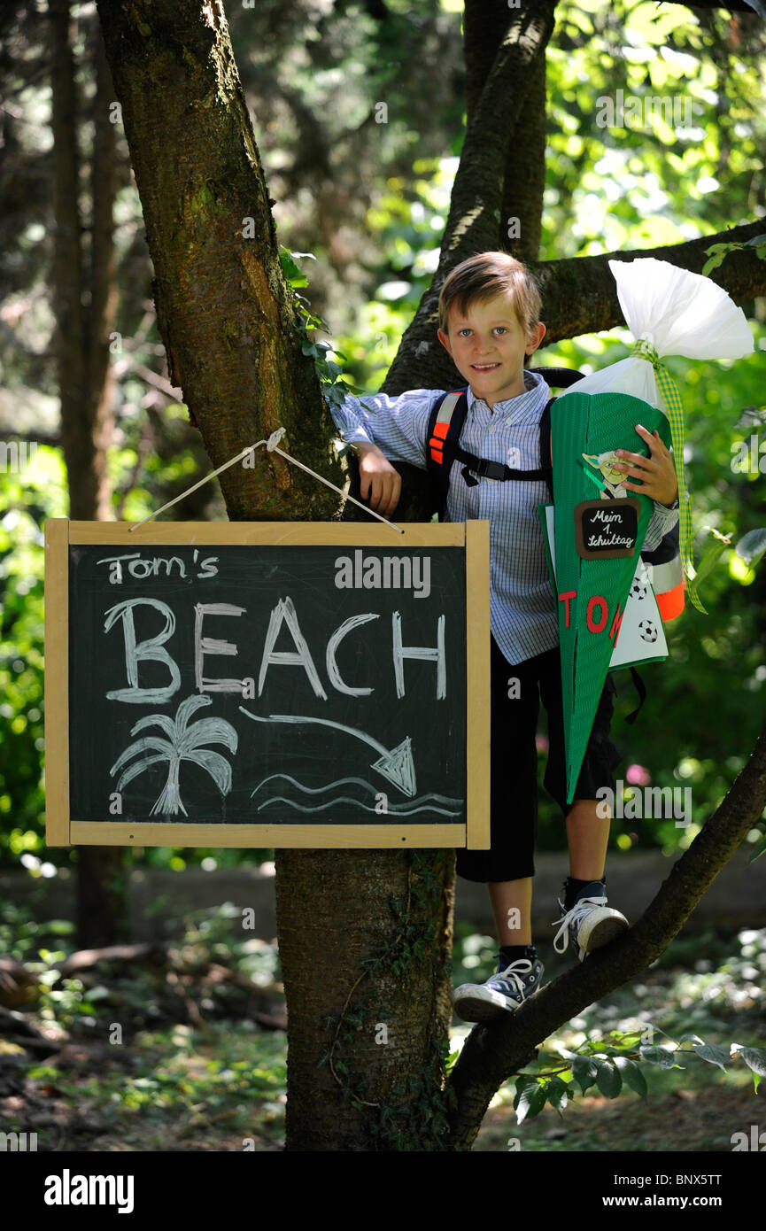 Première journée à l'école. Garçon avec cône en carton dans la cour de l'école. Banque D'Images