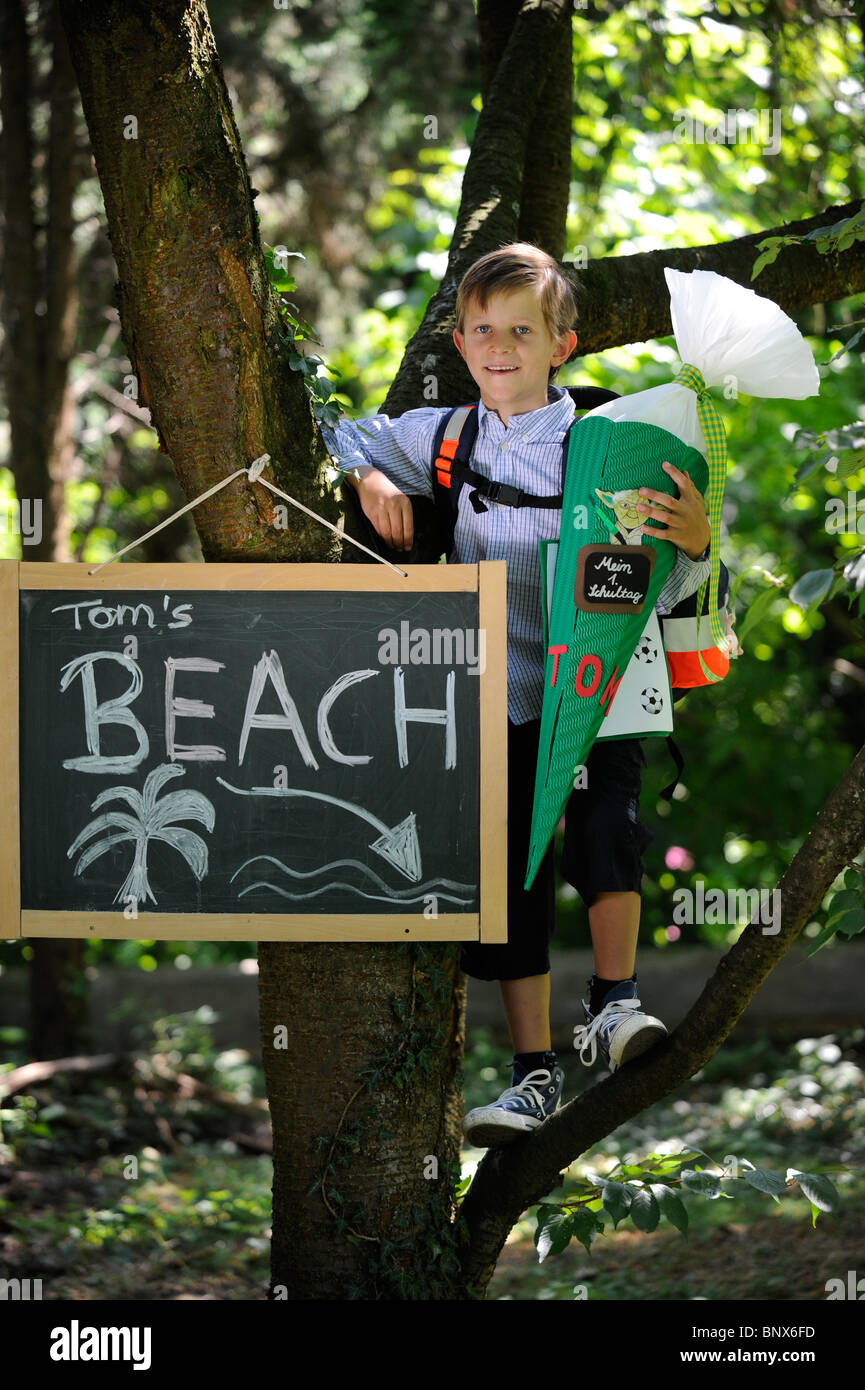 Première journée à l'école. Garçon avec cône en carton dans la cour de l'école. Banque D'Images