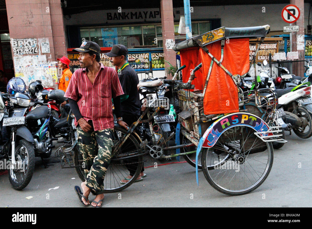 Le Trishaw et rider à Bandung, Indonésie. Banque D'Images