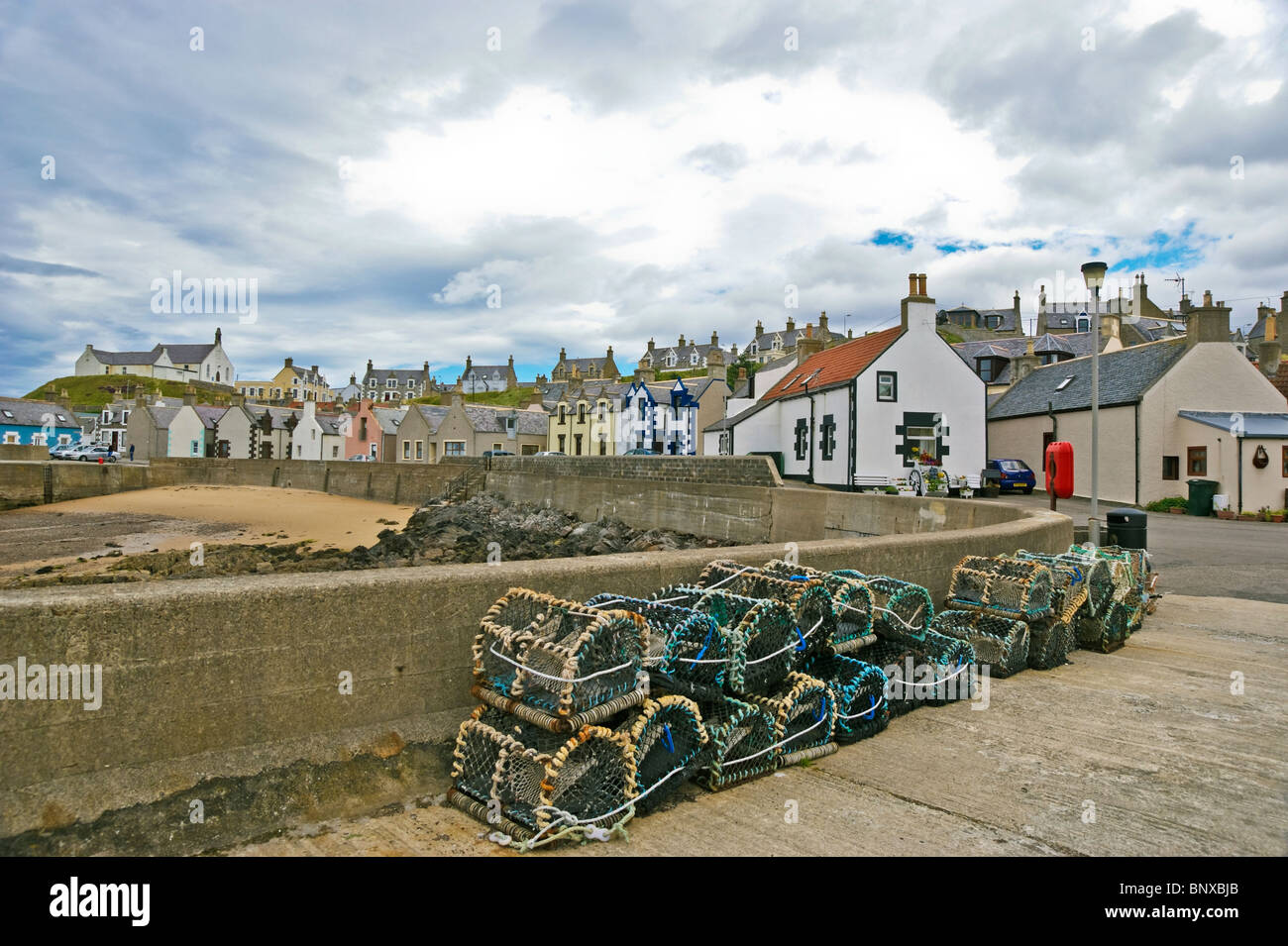 Les engins de pêche sur la jetée et converti maisons de pêcheurs dans le port d'Findochty, dans le comté de Moray nord-est de l'Écosse Banque D'Images