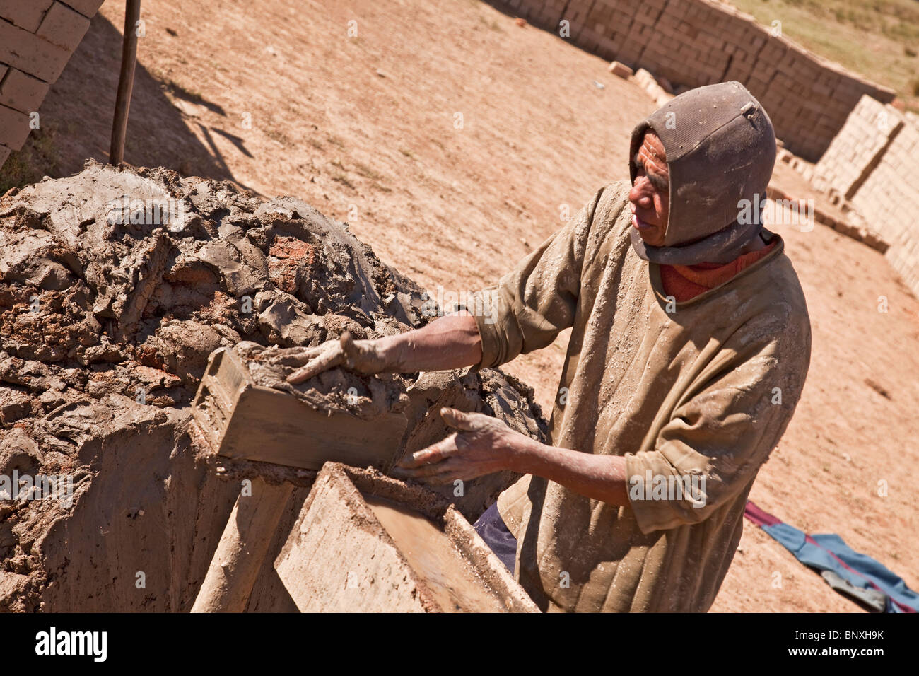 L'homme de faire des briques de boue de l'argile du sol de limon/paddyfields dans le centre de Madagascar Banque D'Images