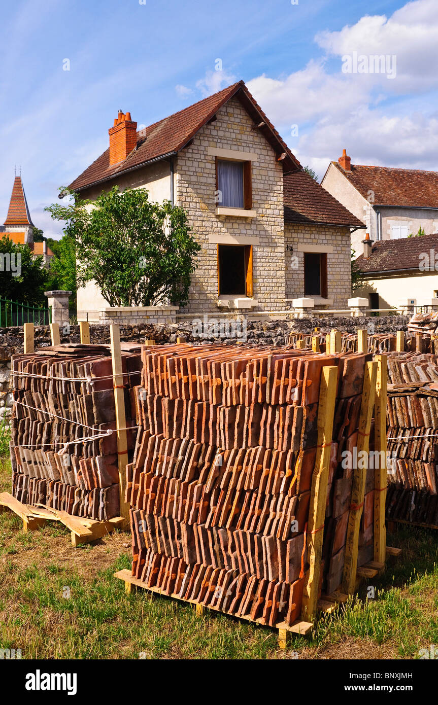 Pile de recyclage de vieux toits d'argile rouge en face de maison modernisée - France. Banque D'Images