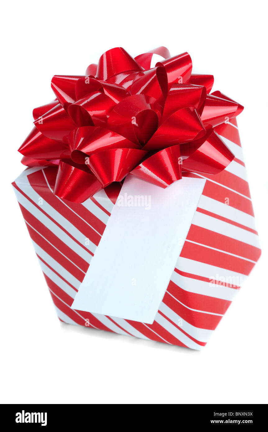 Cadeaux de Noël rouge à rayures enveloppé dans du papier d'emballage, isolé sur un fond blanc avec l'exemplaire de l'espace sur une carte-cadeau Banque D'Images