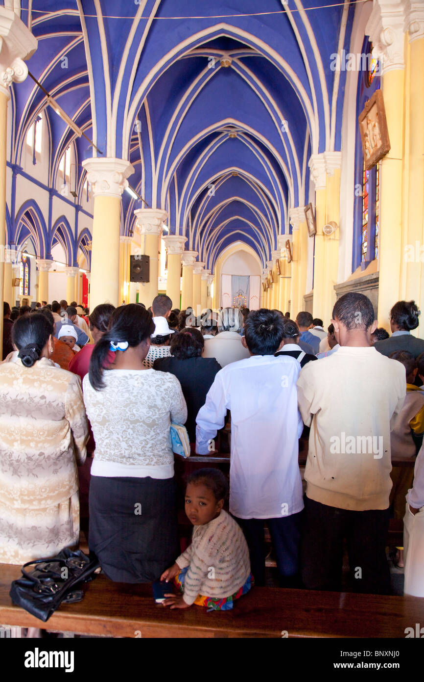 Des fidèles dans la Cathédrale Catholique Antsirabe, Madagascar, au cours de la messe du dimanche matin. Un enfant est à l'arrière. Banque D'Images