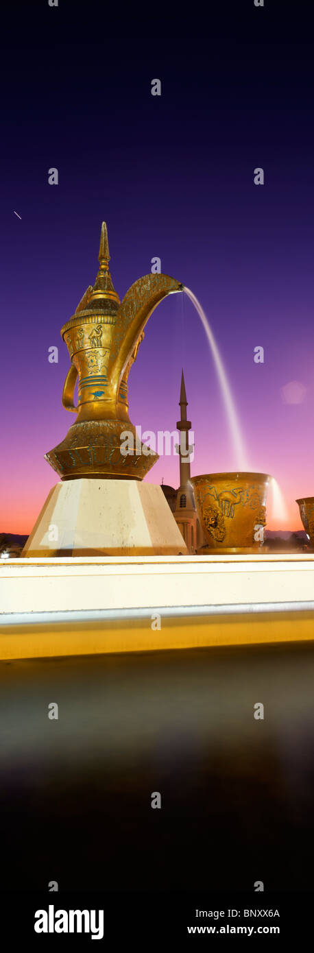 Vue panoramique tourné de coffee pot rond-point distinctif à Fujairah ville au crépuscule, Fujairah, Émirats arabes unis. Banque D'Images