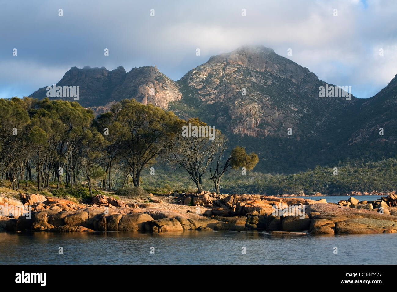 La côte rocheuse de Coles Bay avec les dangers au-delà de montagnes. Parc national de Freycinet, Tasmanie, Australie. Banque D'Images