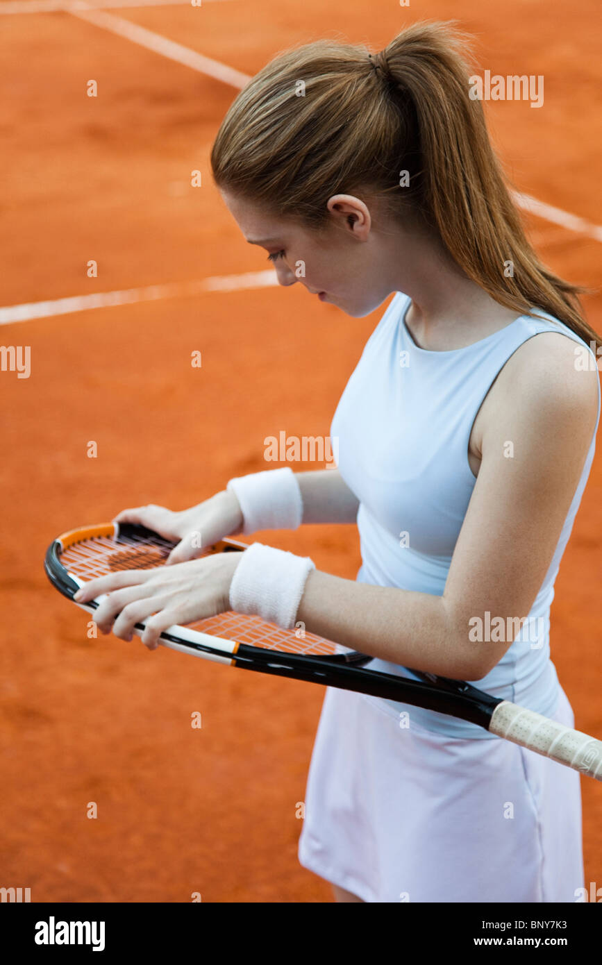 En ajustant son joueur de tennis racket Banque D'Images