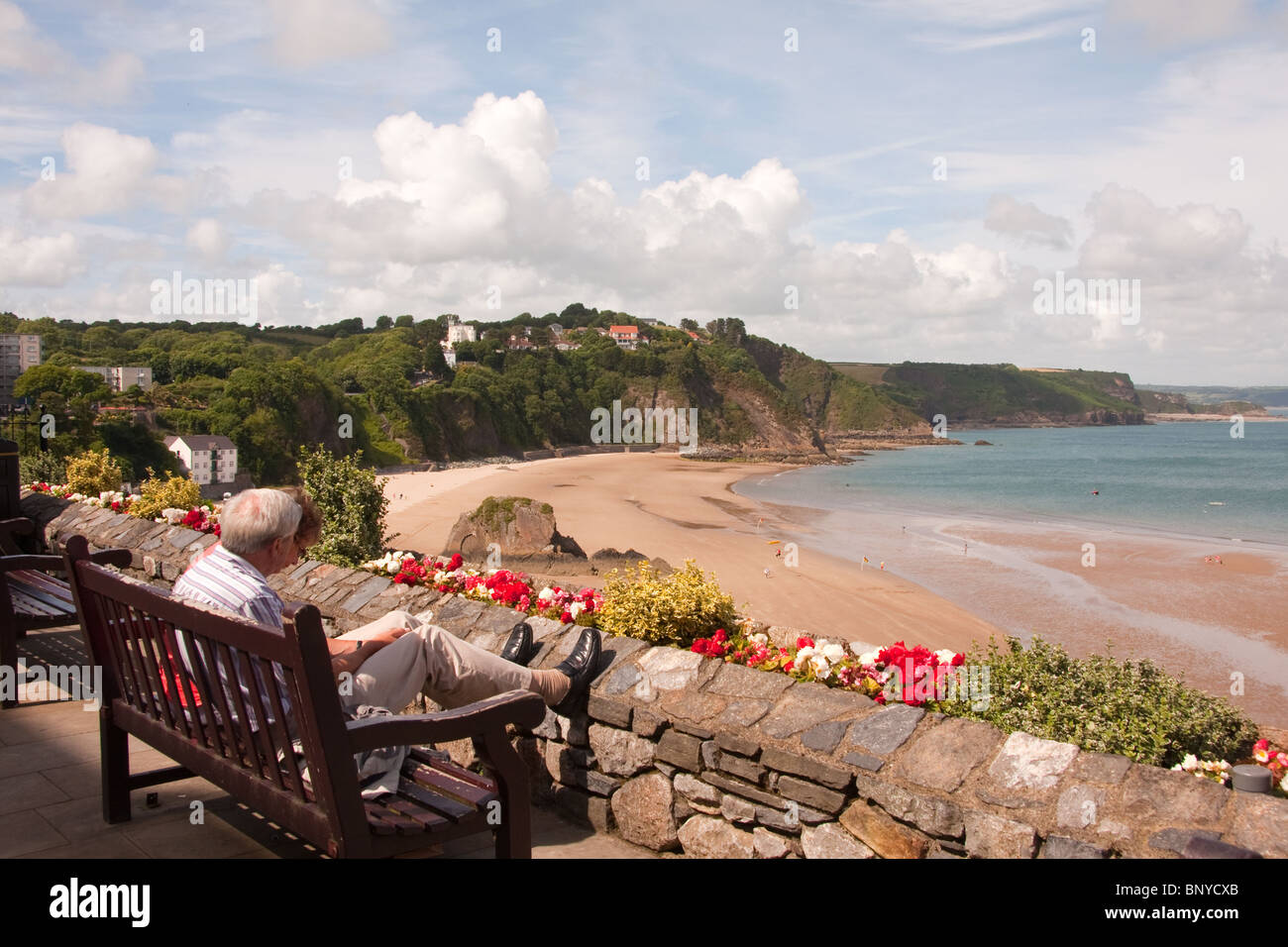 Couple de personnes âgées à la recherche sur plage, Tenby Banque D'Images