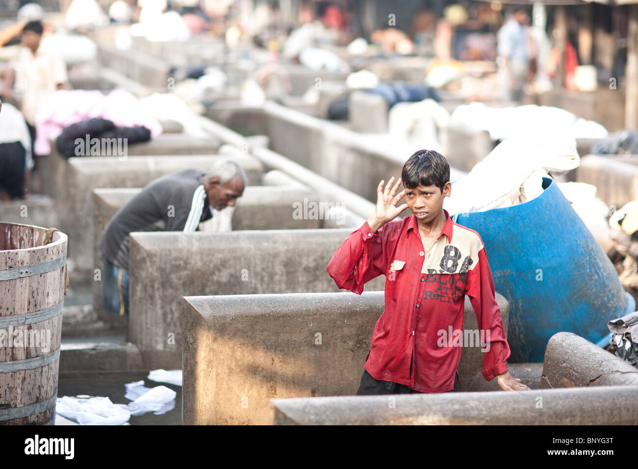 Un jeune Dhobi au travail au Dhobi Ghat, à Mumbai en Inde. Banque D'Images