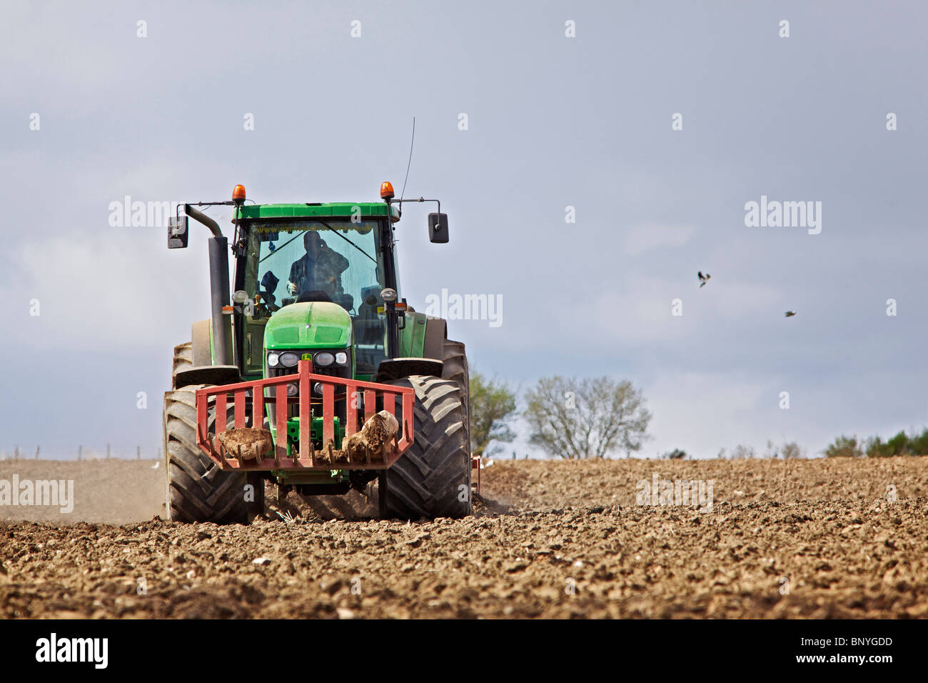 Tracteur John Deere herser un champ dans le Perthshire Banque D'Images