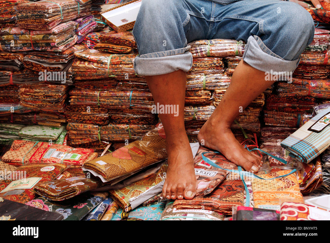 Assis sur un tas de batiks à Bandung, Indonésie. Banque D'Images