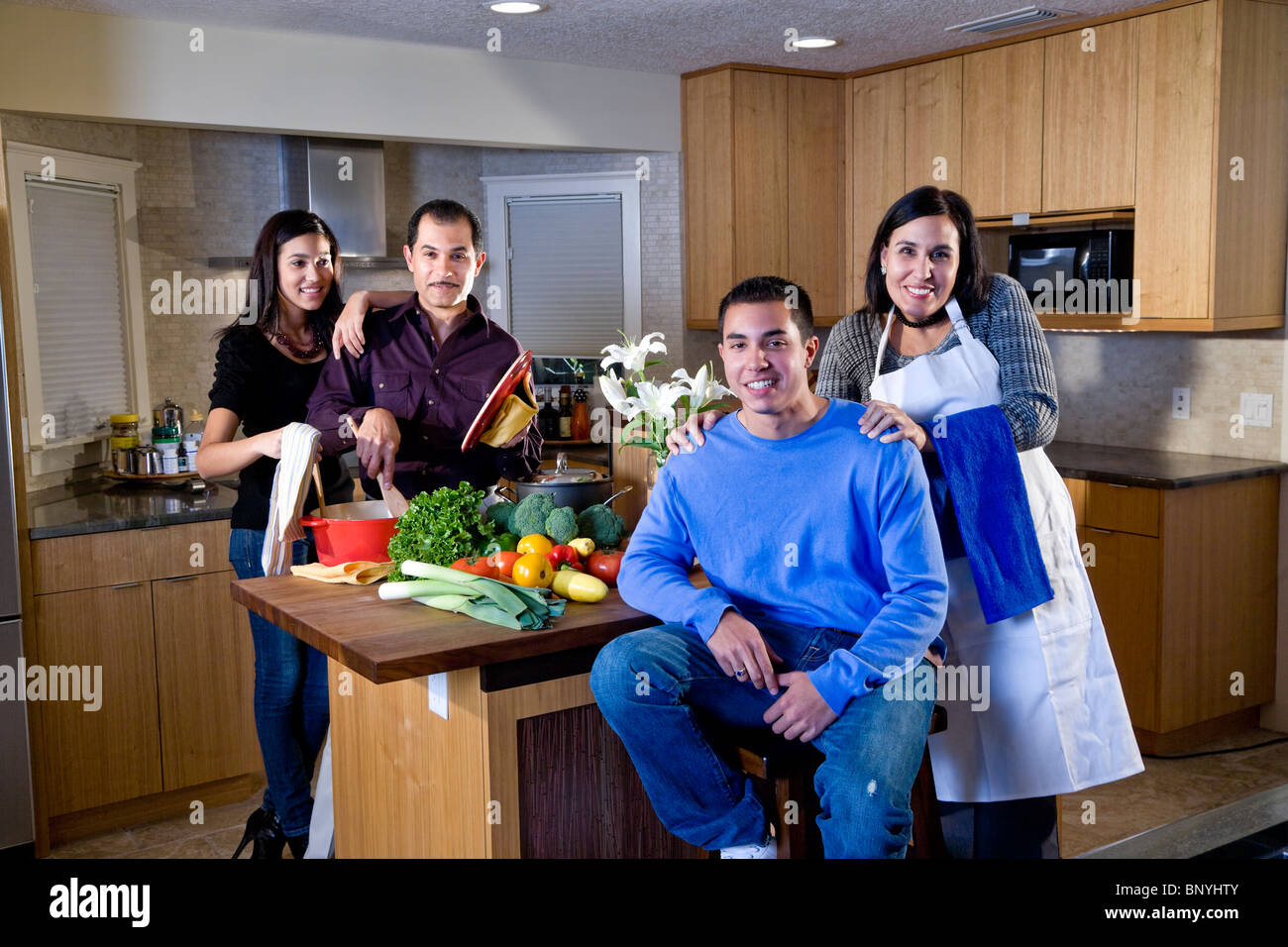 Famille avec adolescents hispaniques cooking together in kitchen Banque D'Images