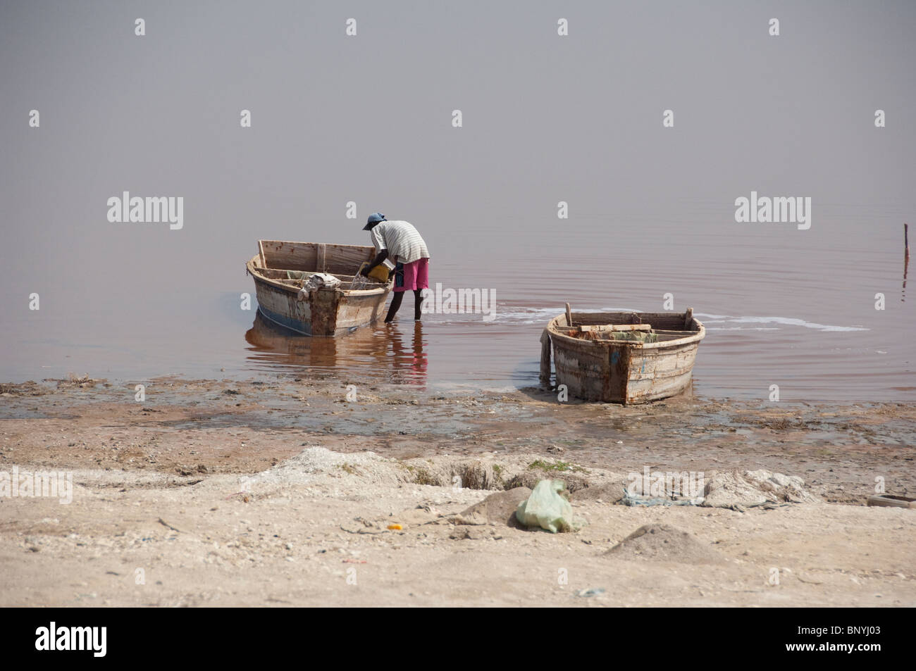 Afrique, Sénégal, Dakar. Le Lac Rose de Retba. La collecte de sel le long des côtes salées bateaux de Lac Retba. Banque D'Images