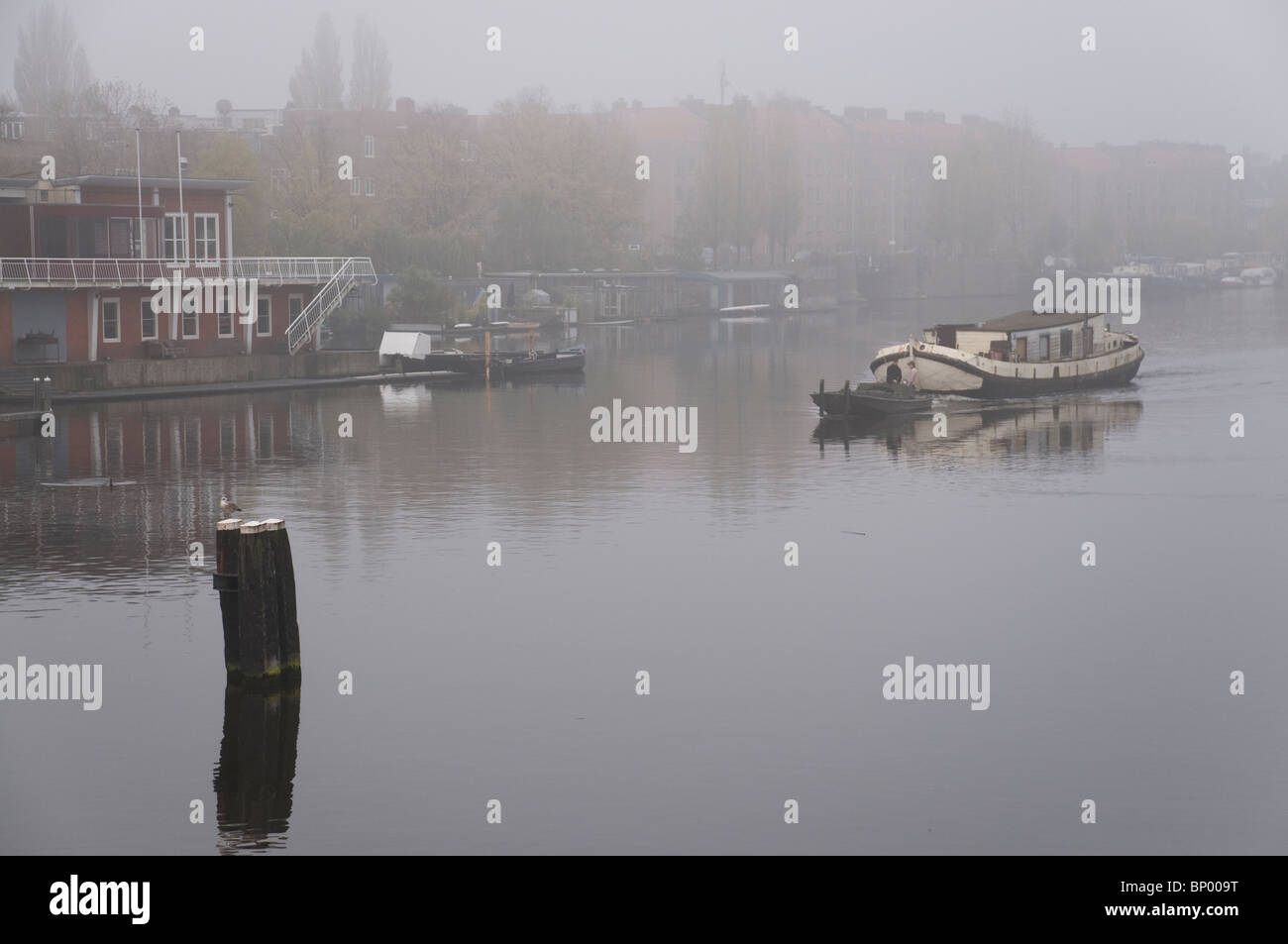 Remorquage d'une maison bateau le long d'un canal à Amsterdam aux Pays-Bas. Banque D'Images