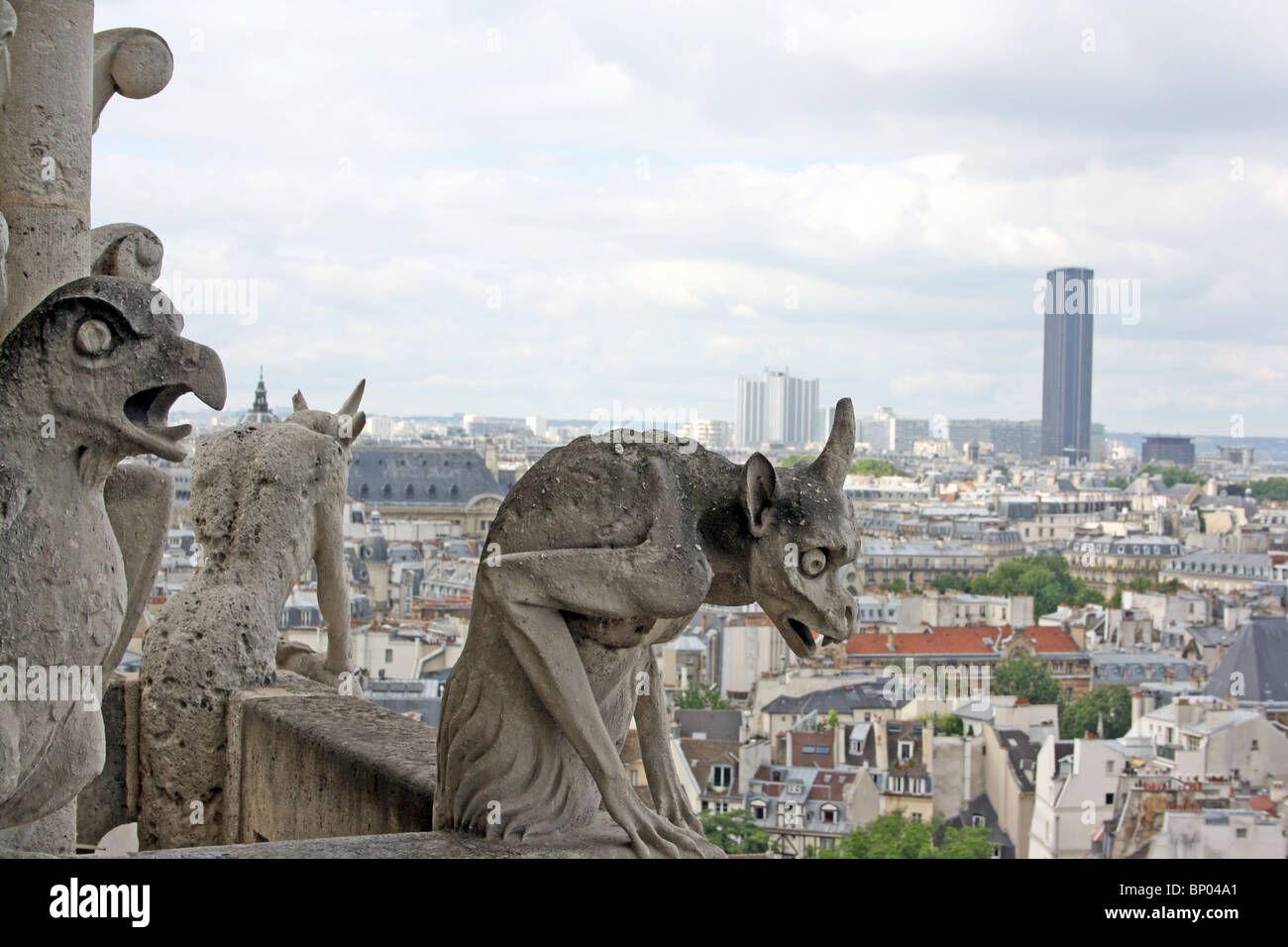 La Cathédrale Notre Dame, Paris. Chimères 20, 21 & 22 sur le balcon, avec la Tour Montparnasse en arrière-plan. Banque D'Images