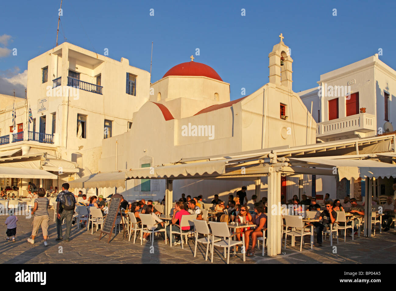 L'église et le café de la chaussée au port de Mykonos, l'île de Mykonos, Cyclades, Mer Égée, Grèce Banque D'Images