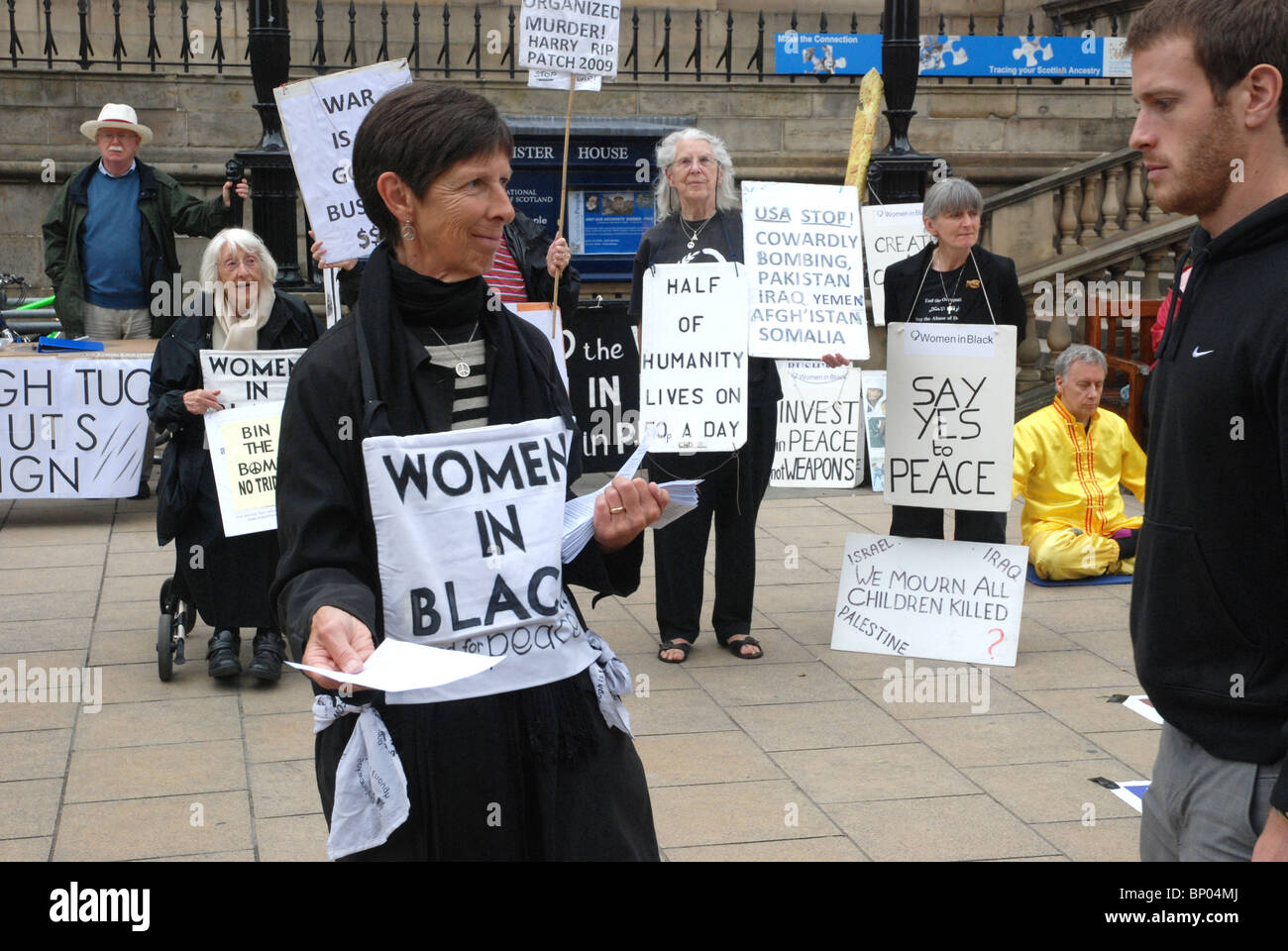 Membre de "Femmes en Noir" distribution de tracts pendant une manifestation silencieuse sur Princes Street, Edinburgh. Banque D'Images