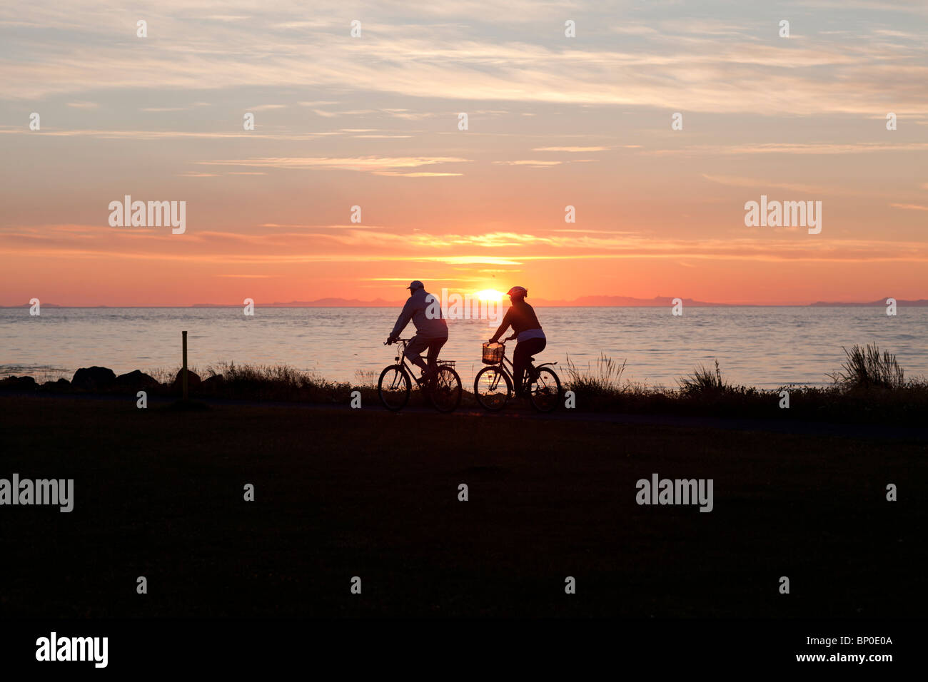 Les gens de la bicyclette au coucher du soleil sur la plage de Grotta, Islande Banque D'Images