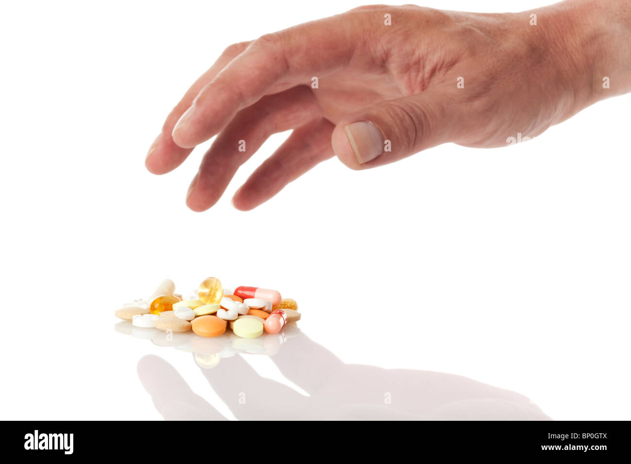 L'abus de drogues - hand reaching out pour un tas de médecine pills Banque D'Images