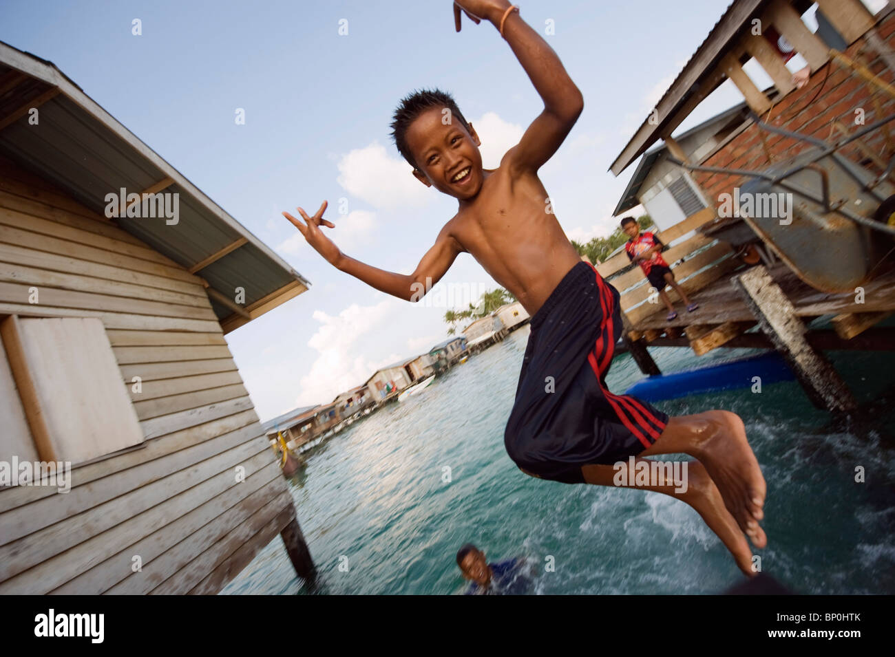 L'Asie du Sud, la Malaisie, Bornéo, Sabah, Mabul Island, garçon sautant dans la mer Banque D'Images