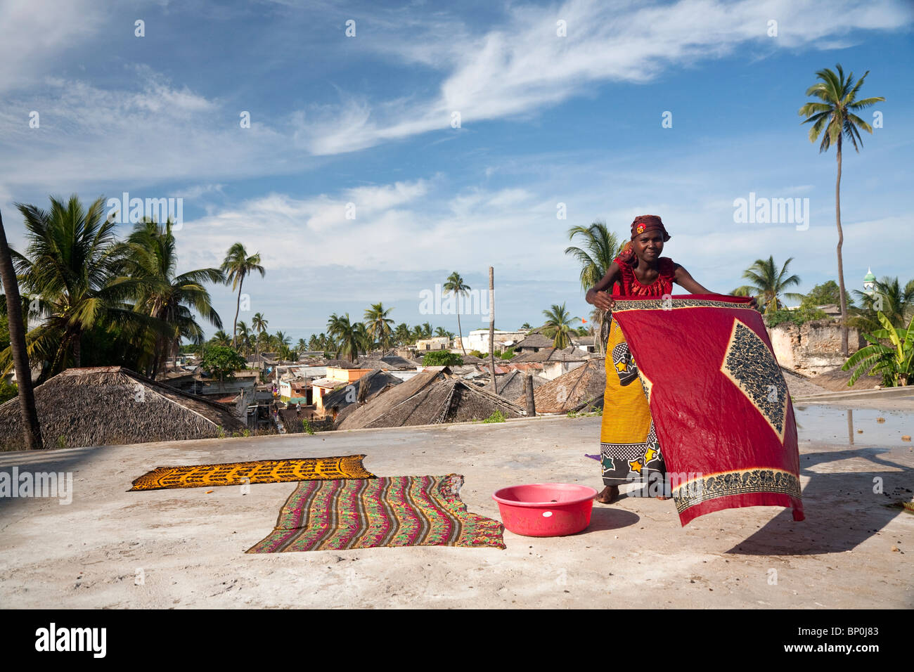Le Mozambique, l'Ihla de Moçambique, Stone Town. Une dame sèche aux couleurs vives, Kapolanas sur un toit à Stone Town. Banque D'Images