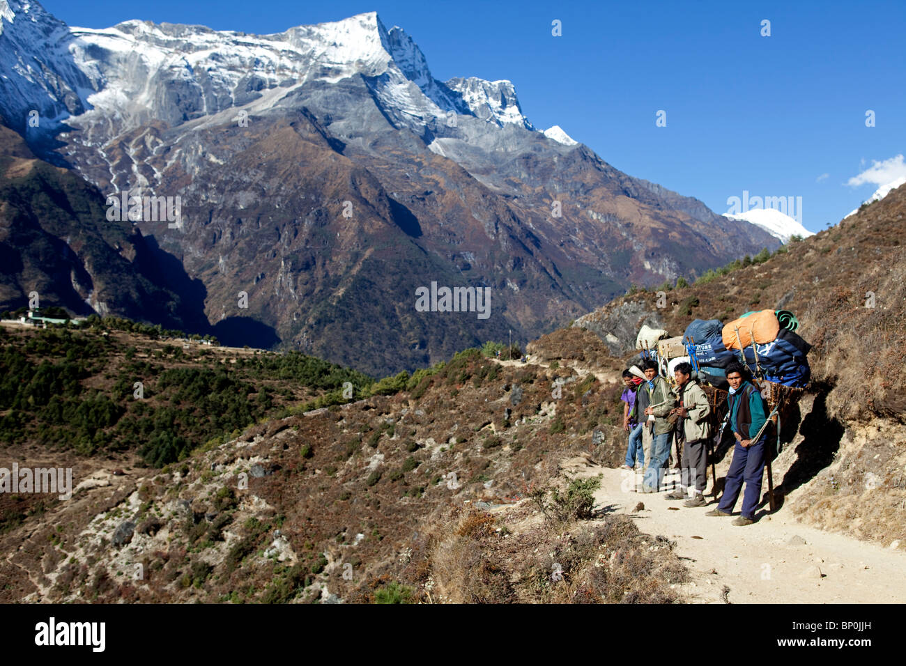 Le Népal, Everest, Région de la vallée de Khumbu. Porteurs d'un trek dans la vallée du Khumbu reposant sur le côté du camp de base de l'Everest trail. Banque D'Images