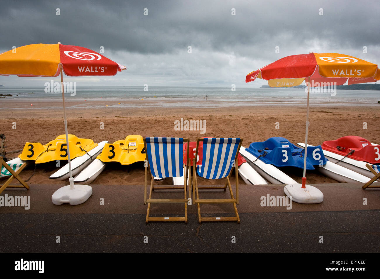 Ciel d'orage sur les parasols et transats à la plage de Goodrington Sands, Devon Banque D'Images
