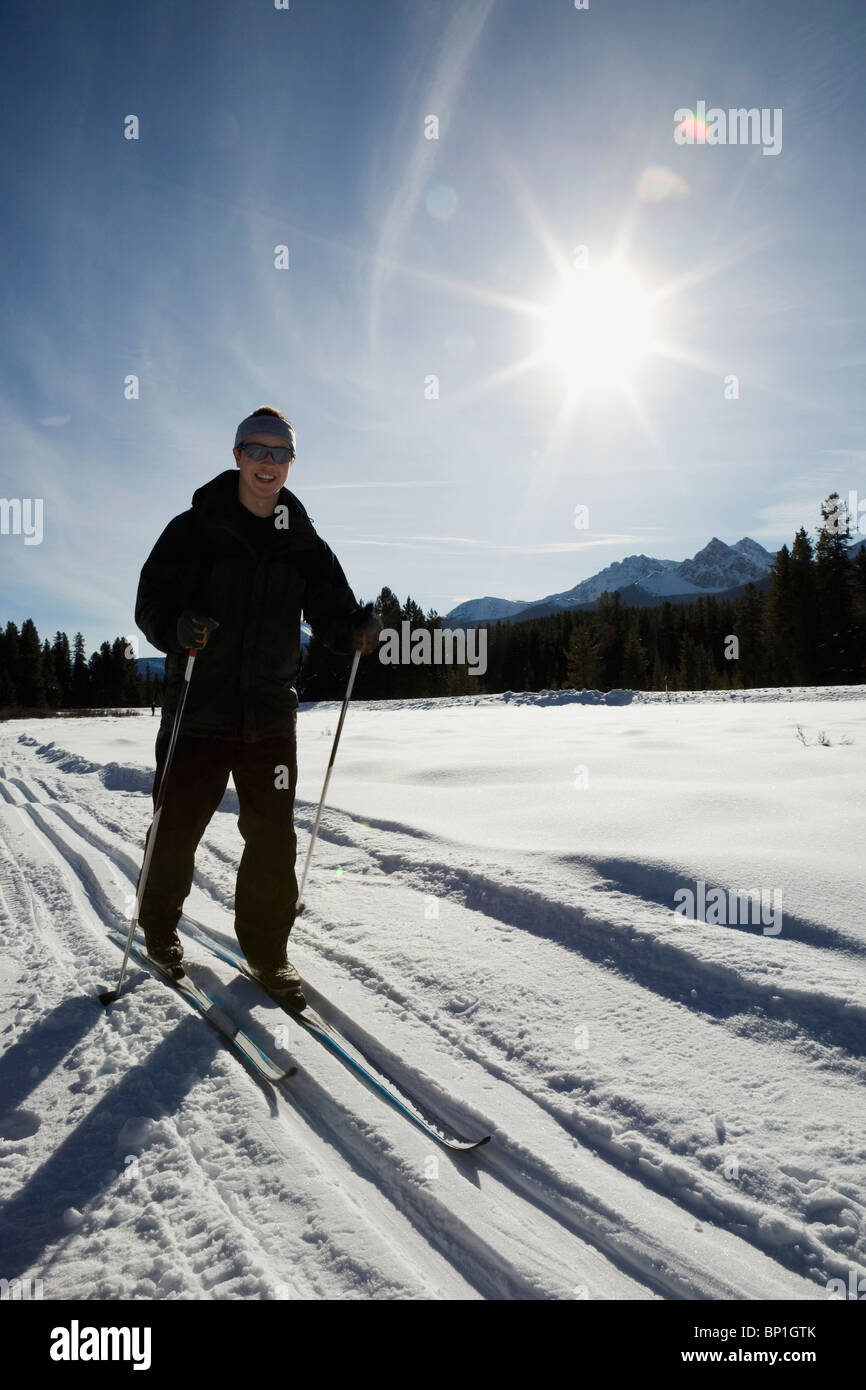 Lake Louise, Alberta, Canada ; La fondeuse sur un sentier avec un Sunburst Banque D'Images
