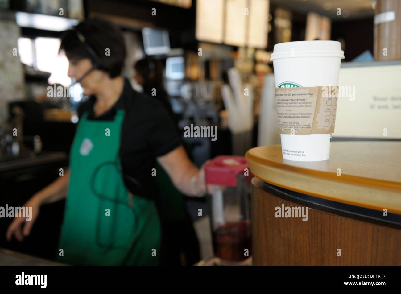 Avec Starbucks barista et tasse de café sur le comptoir. Banque D'Images