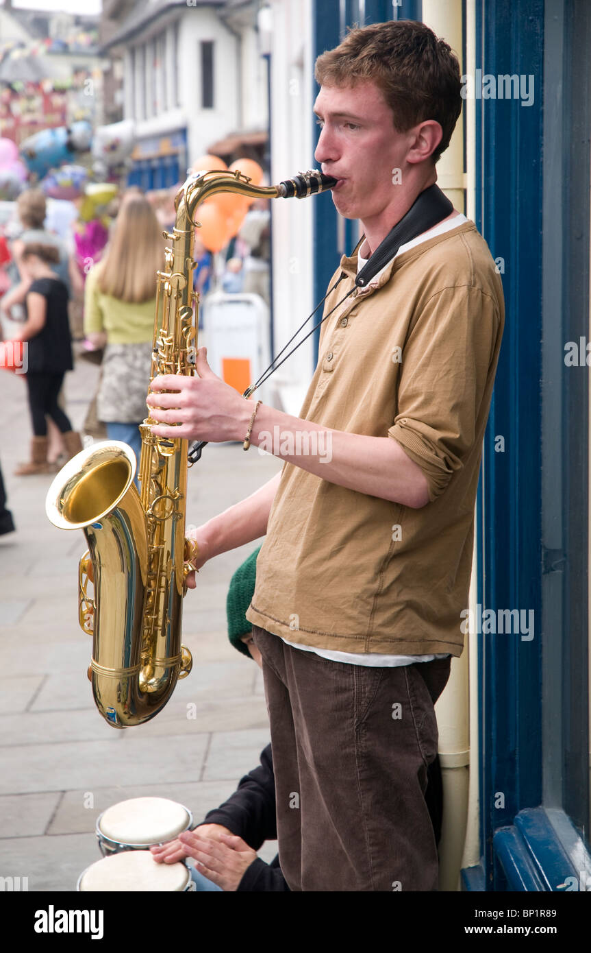 Un jeune musicien ambulant dans les rues de Brecon avec un saxaphone au Jazz Festival week-end 2010 Banque D'Images