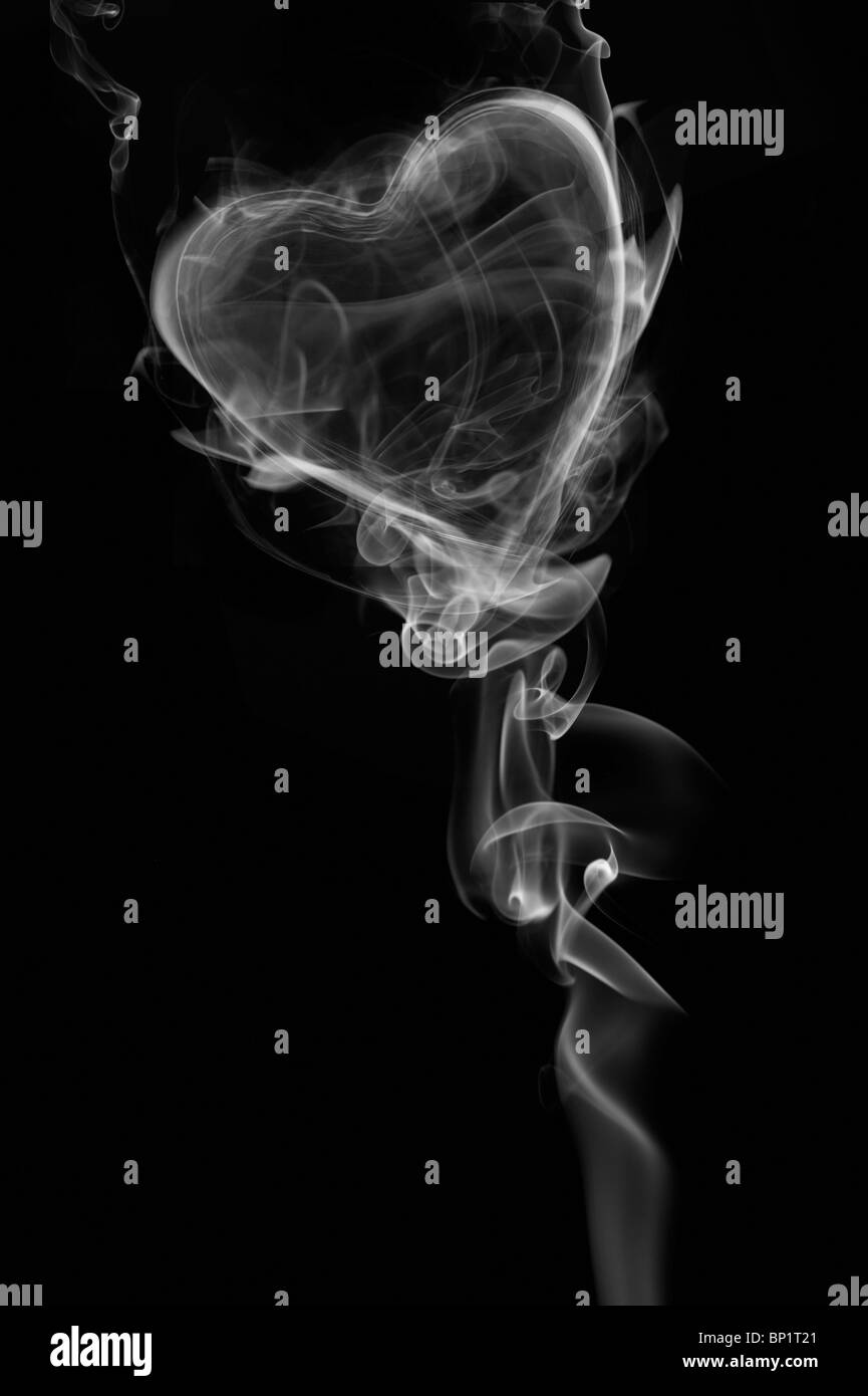 Traînées de fumée blanche en forme de Cœur sur un fond noir Banque D'Images