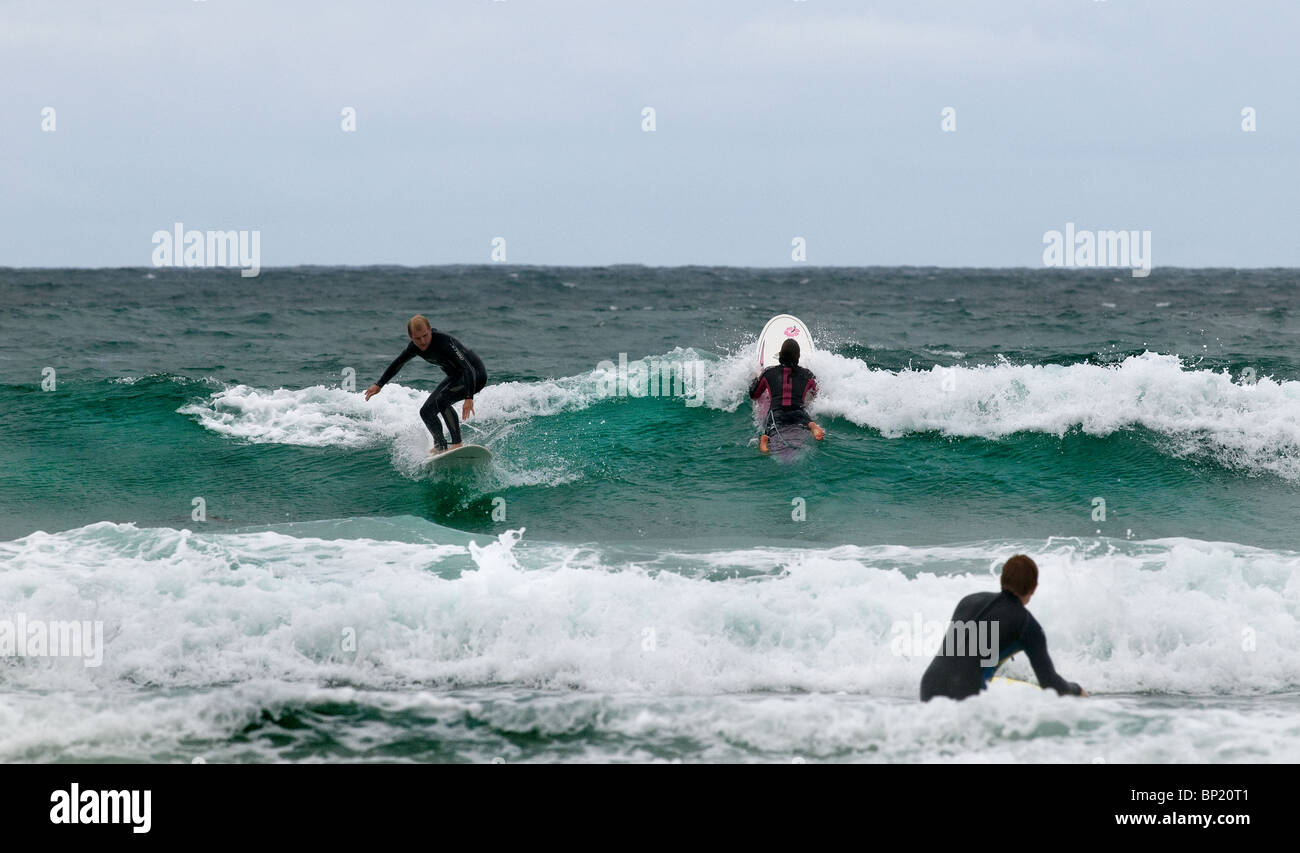 Surfers dans la mer à Newquay en Cornouailles Banque D'Images