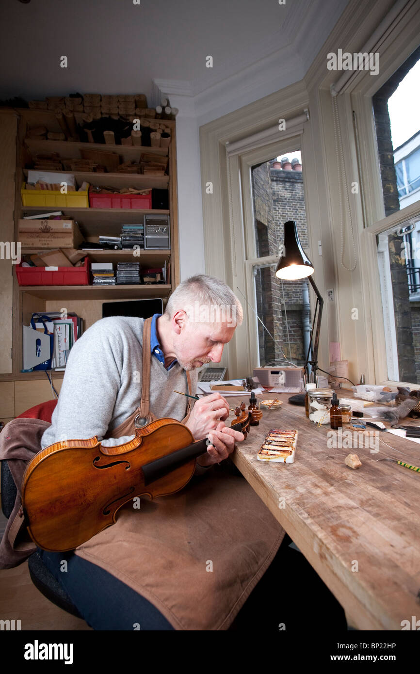 Un restaurateur de violon classique sur un instrument de travail dans son atelier, Londres, Royaume-Uni. Photo:Jeff Gilbert Banque D'Images