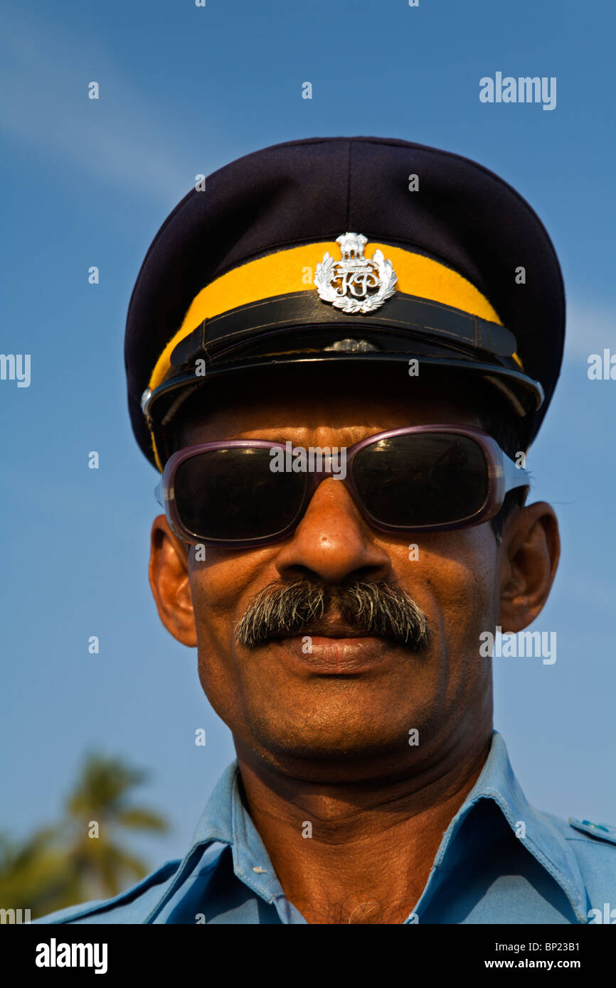 L'Inde. Kerala. Fier Police touristique avec le plus cool des lunettes de soleil sur la plage de Varkala Banque D'Images