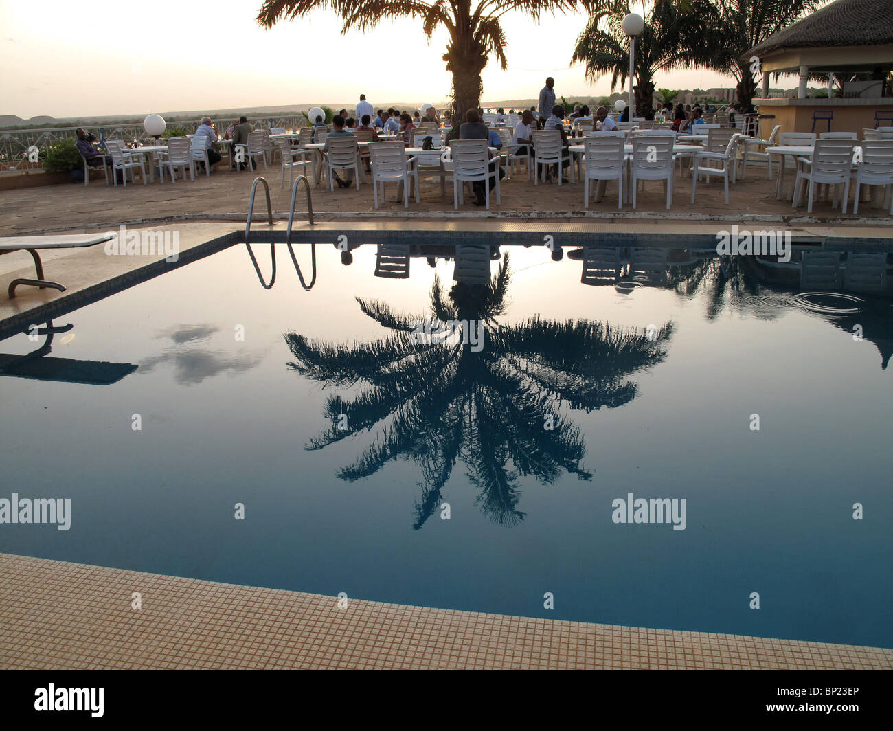 Le Niger. Niamey. Grande piscine de l'hôtel avec la réflexion de palm tree Banque D'Images